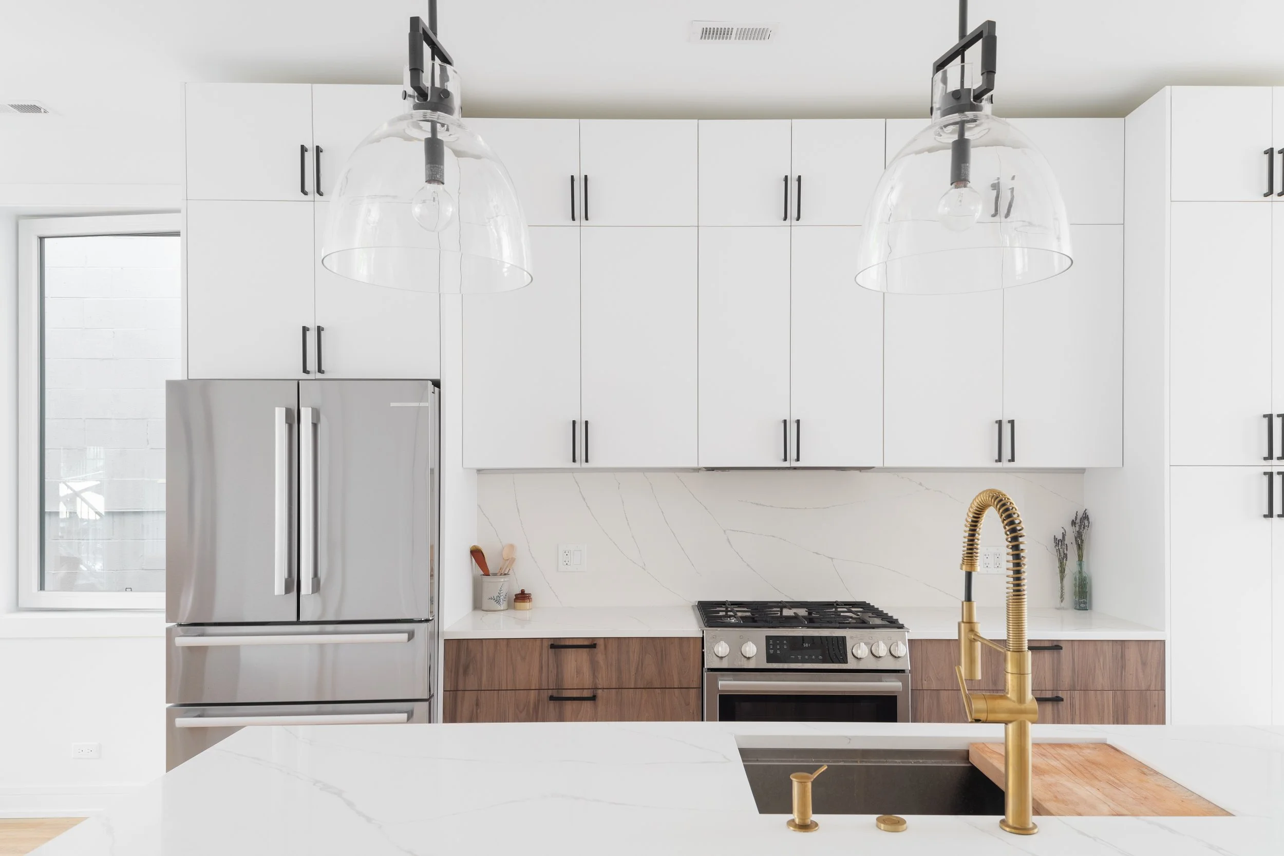 White kitchen cabinets with gold hardware and kitchen island.