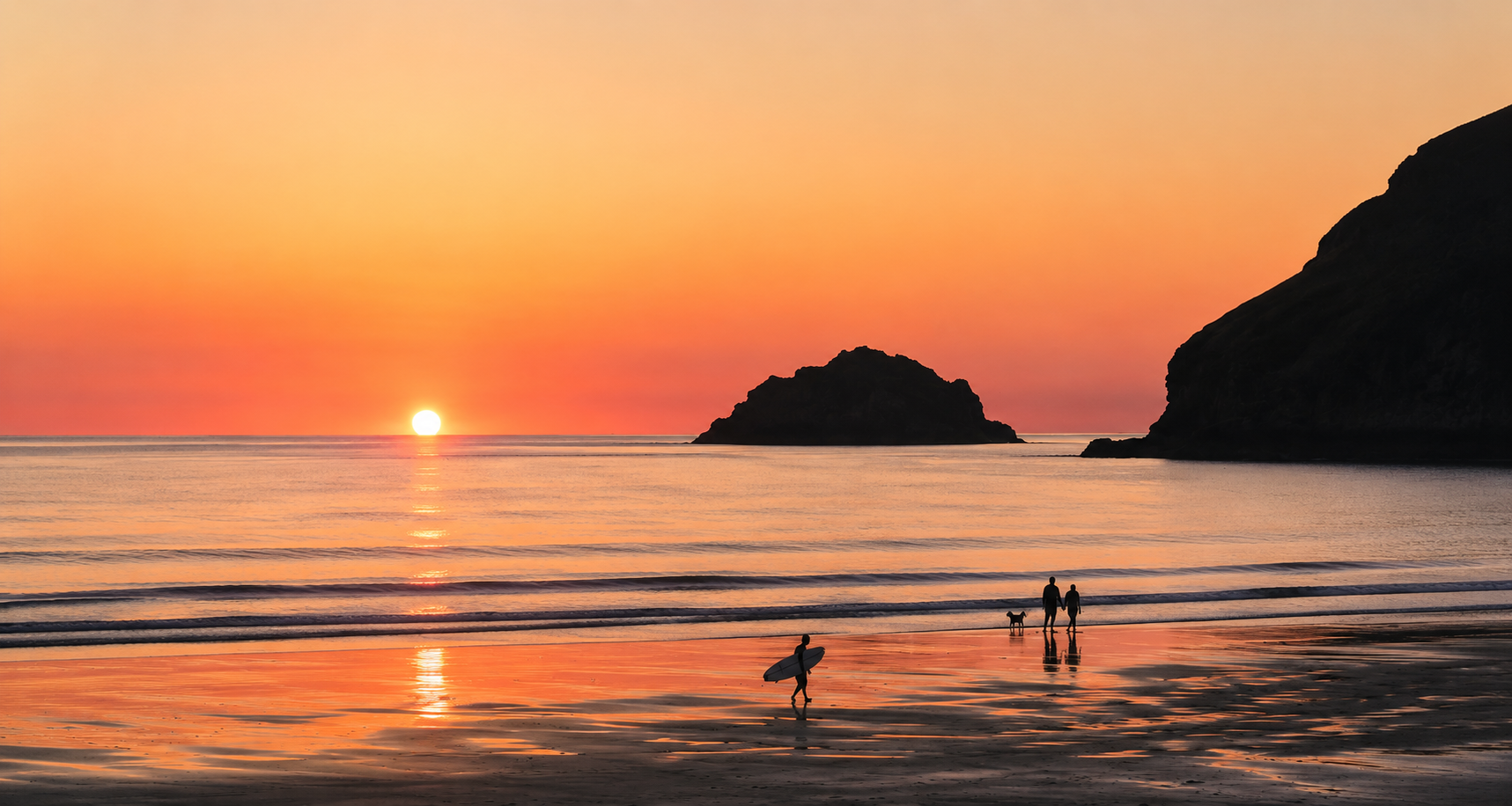 Sunset over the ocean with silhouettes of people, including a surfer carrying a surfboard, a couple holding hands with a dog, and large rocky formations in the background.