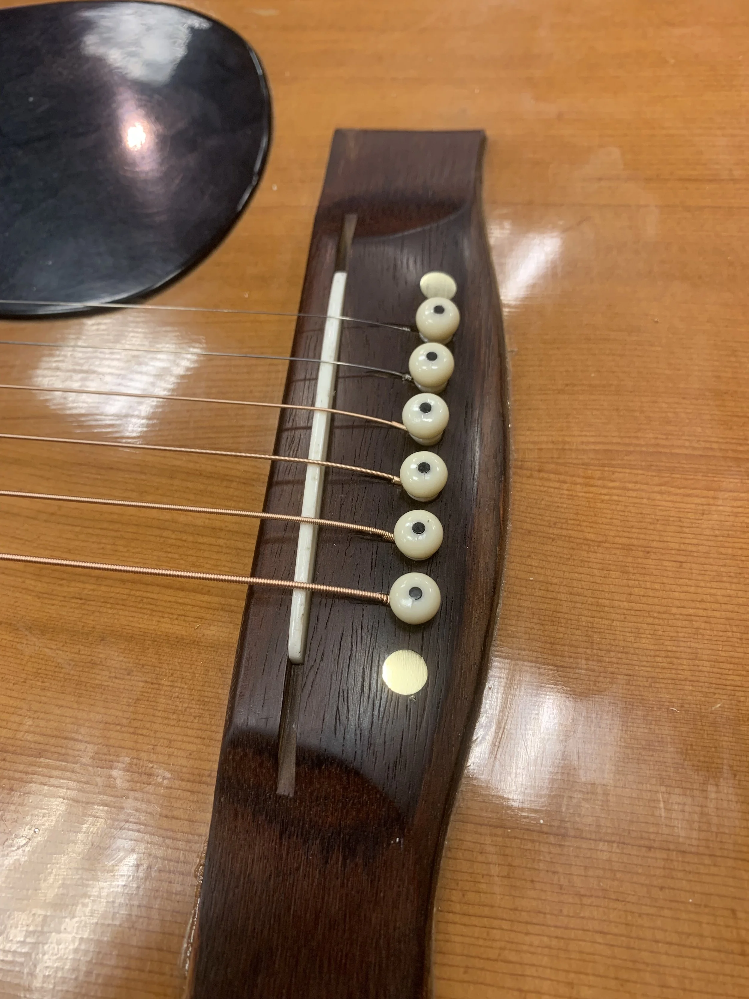 Completed bridge reglue on an old Yamaha, fitted with brass pins.