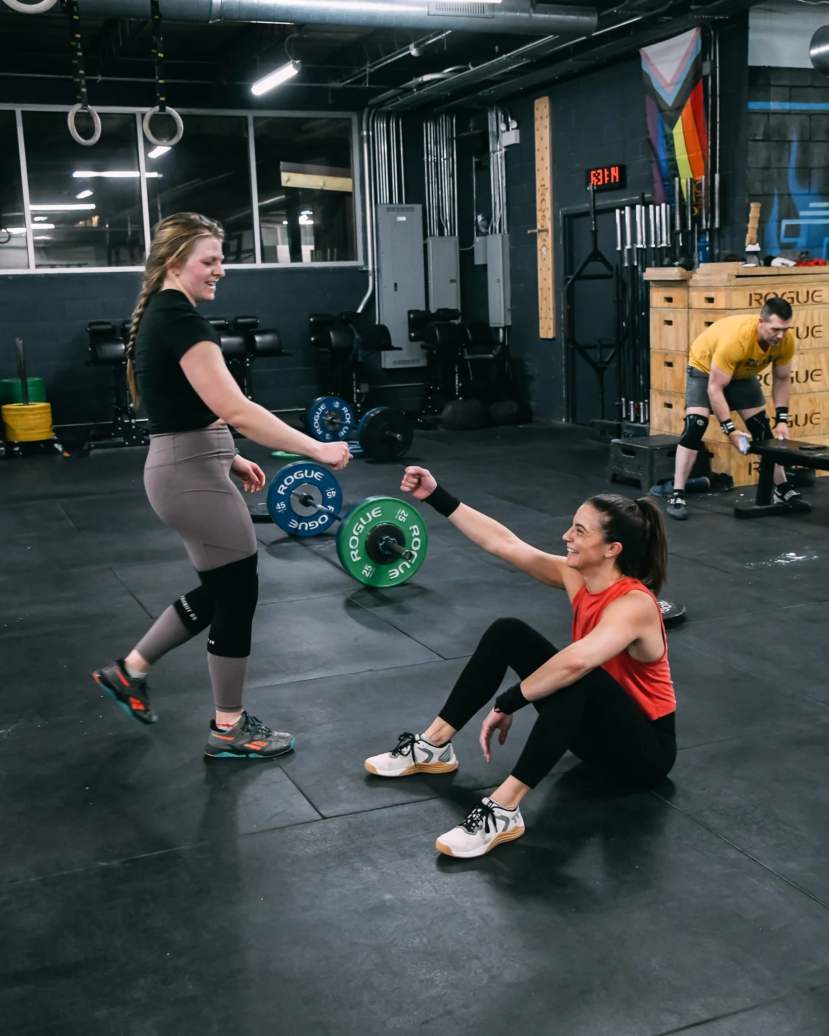 Two female CrossFit athletes fist bumping after a workout at Feast Fitness in Ravenswood, Chicago