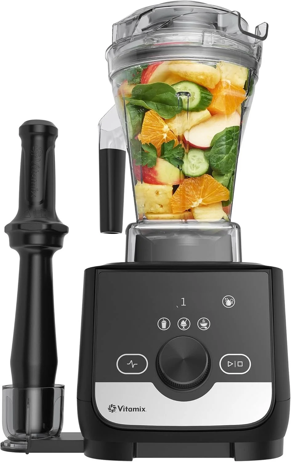 Vitamix blender filled with assorted fruits and vegetables, including apples, oranges, cucumbers, pineapple, bananas, spinach, and parsley.