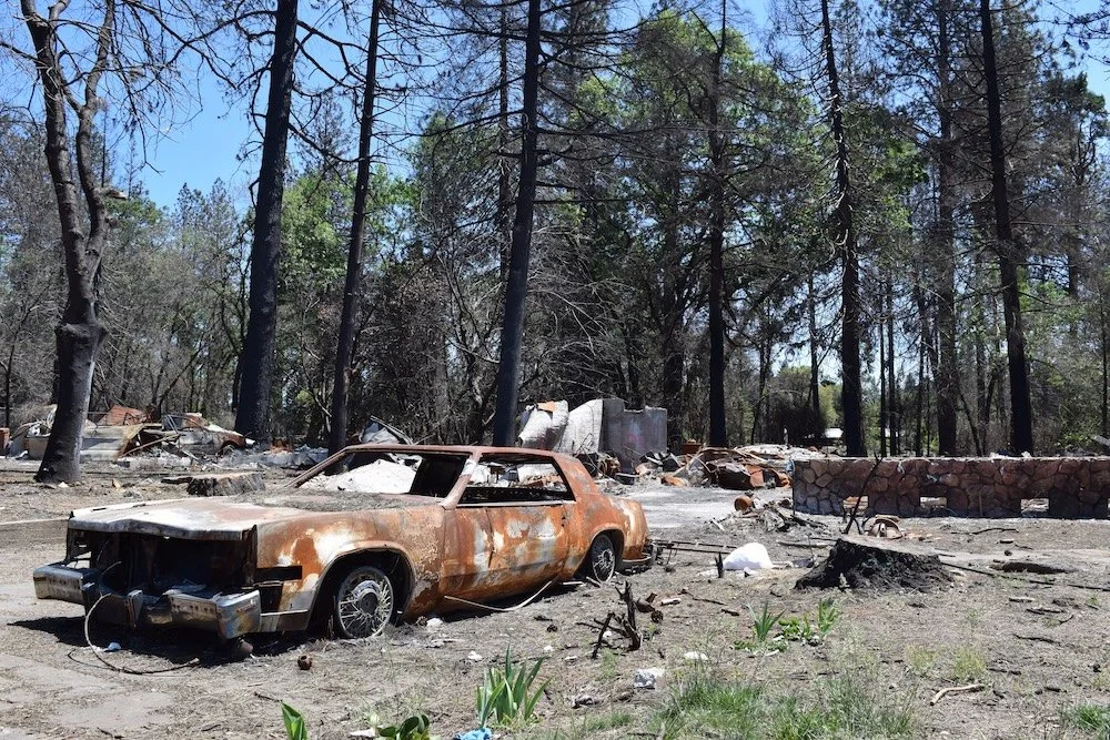 Burnt out car and remains of a home from California's Camp Fire