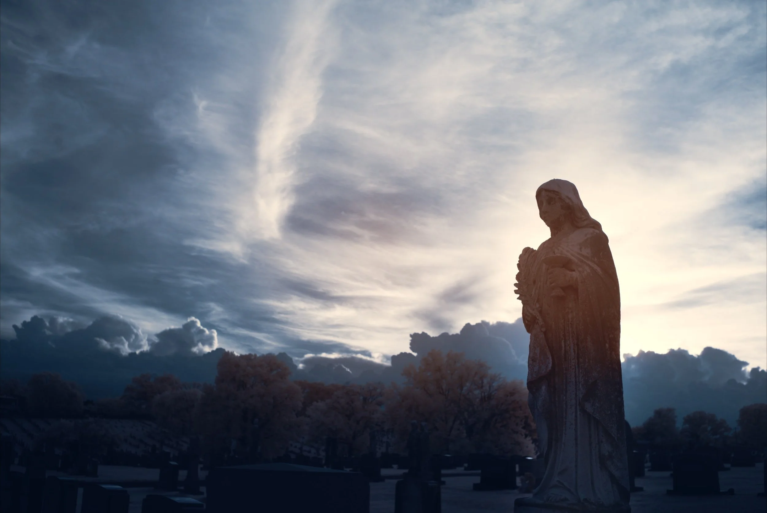 An infrared image of a cemetery with stormclouds in the background