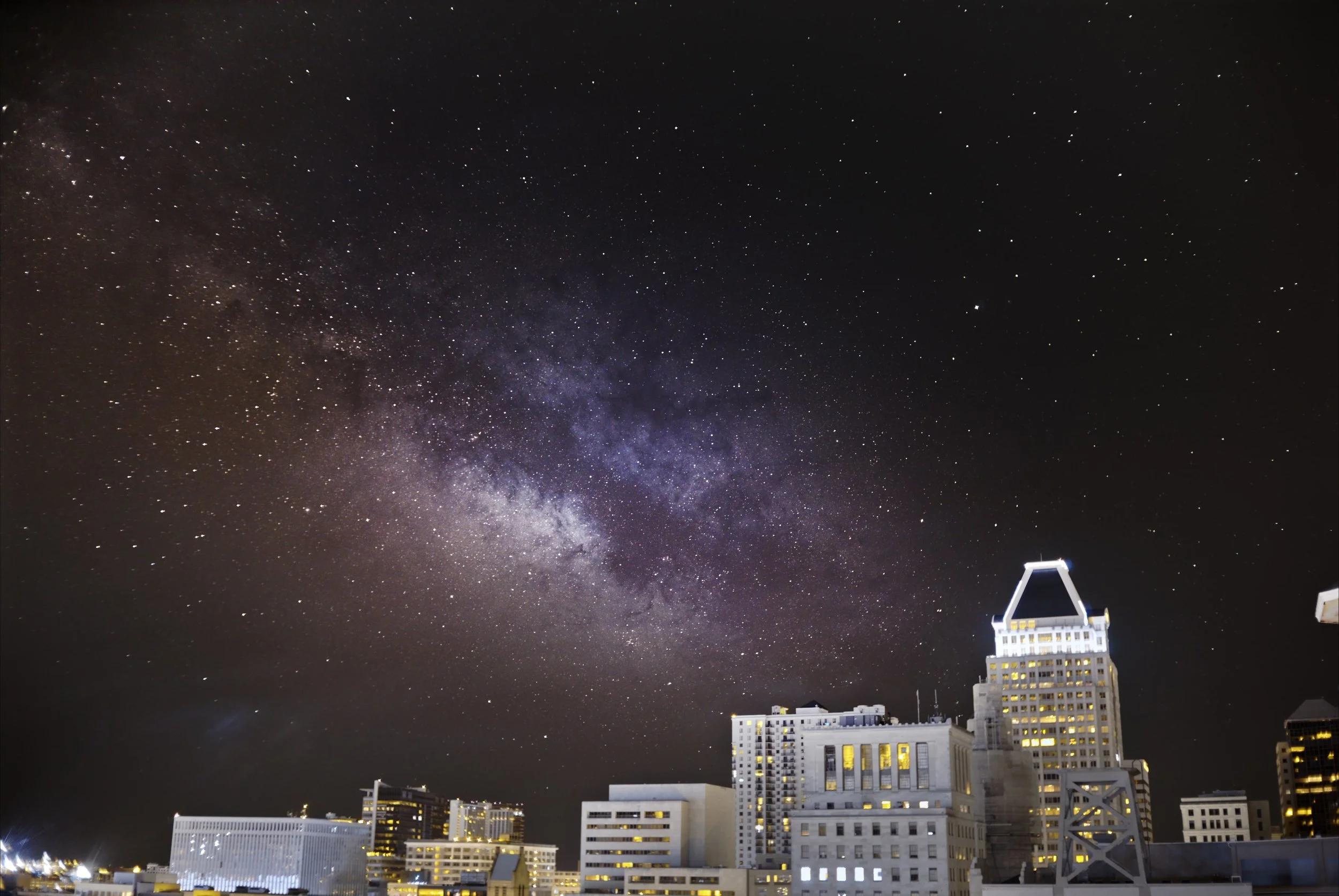 An infrared image of the milky way rising over Baltimore Maryland with tall buildings in the foreground