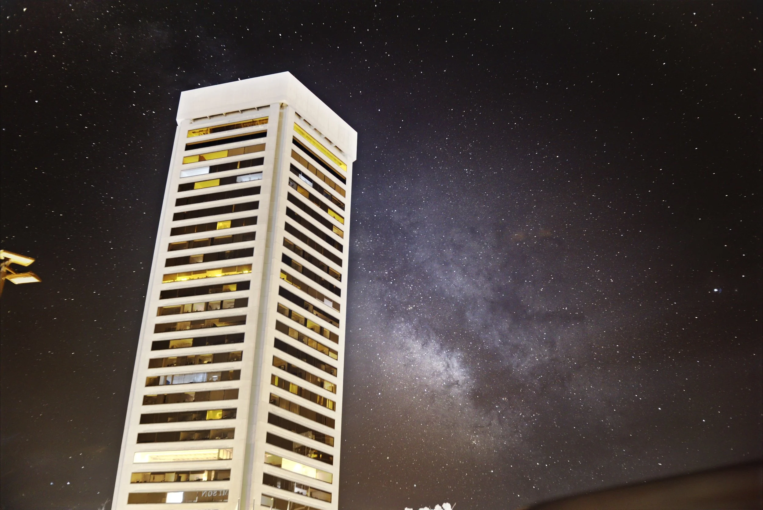 An infrared image of the milky way rising over Baltimore Maryland with tall buildings in the foreground