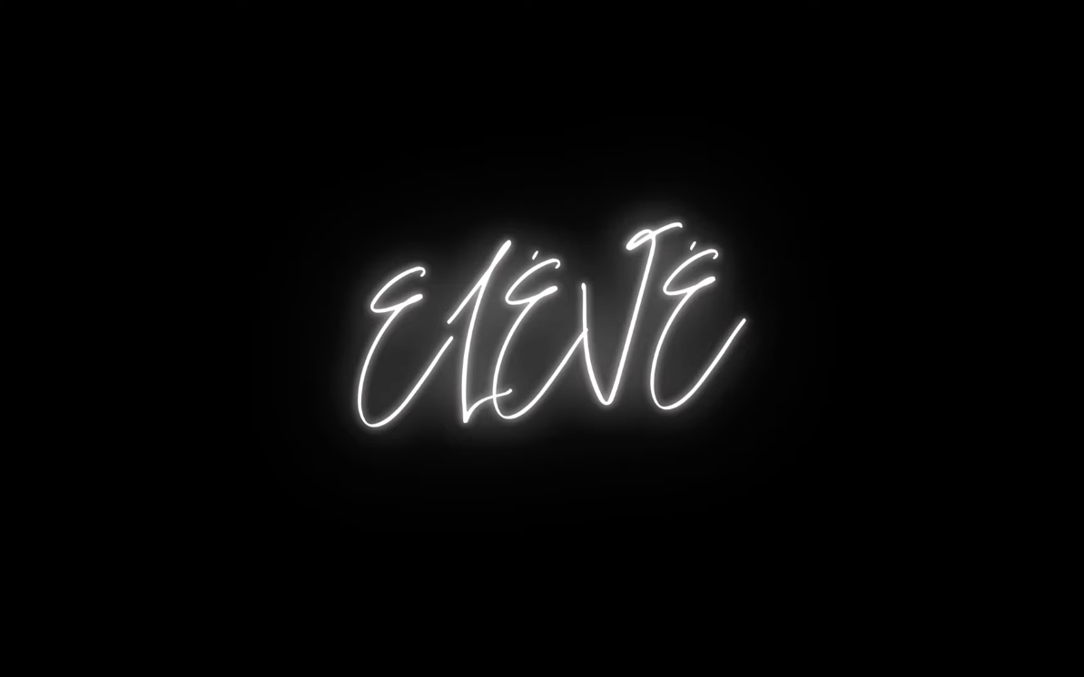 Neon sign with the word "EAT" written in cursive white lights against a black background.