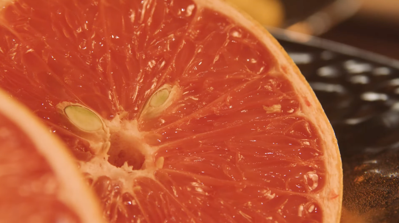 A close-up of an orange half showing the juicy flesh and seeds inside.