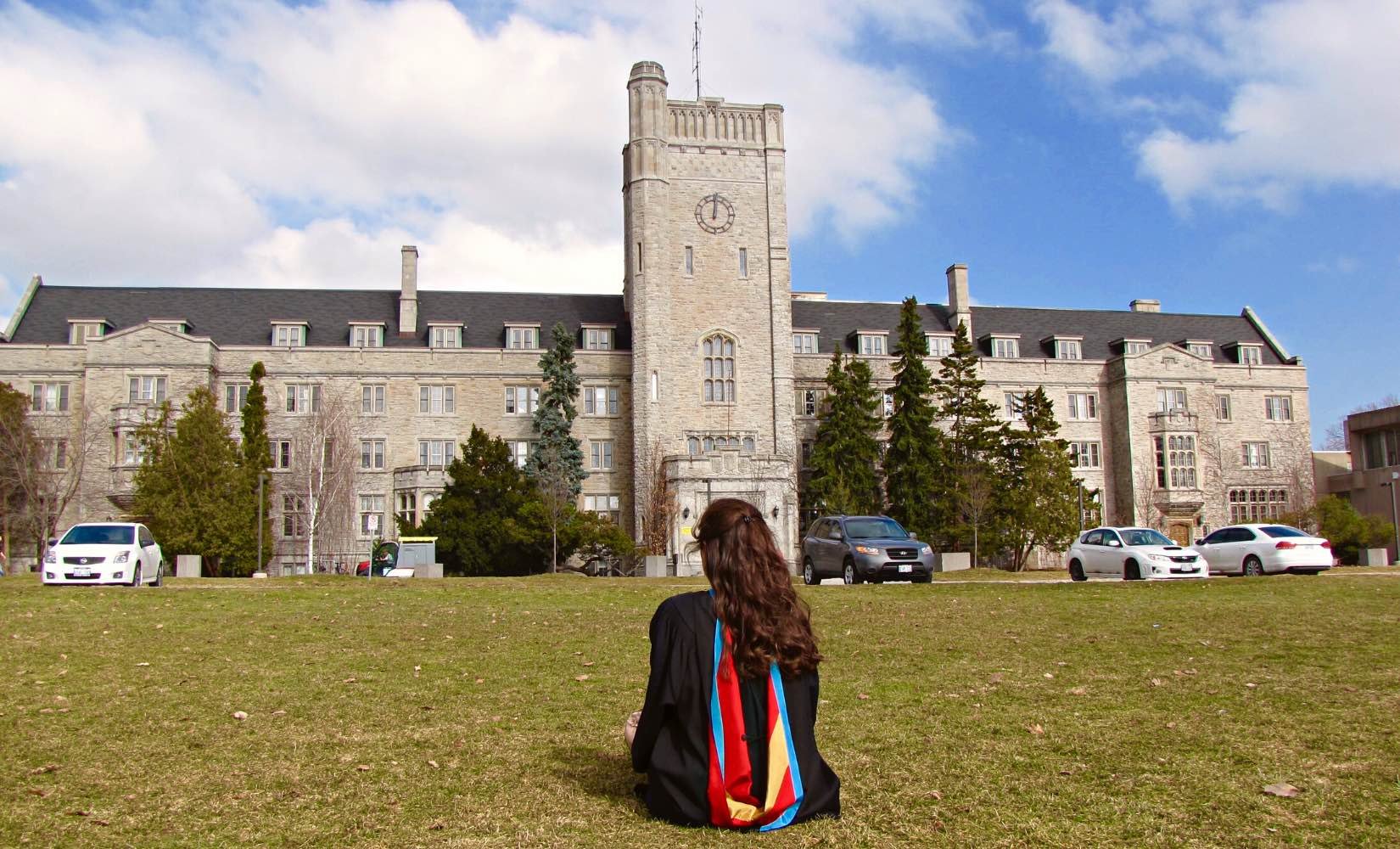 Sitting on the grass on graduation day after the ceremony in my graduation robe