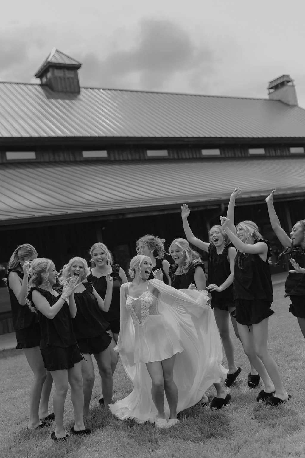 Bride celebrates with her bridesmaids as they cheer and toss flower petals outside the wedding venue, capturing a joyful wedding day moment.