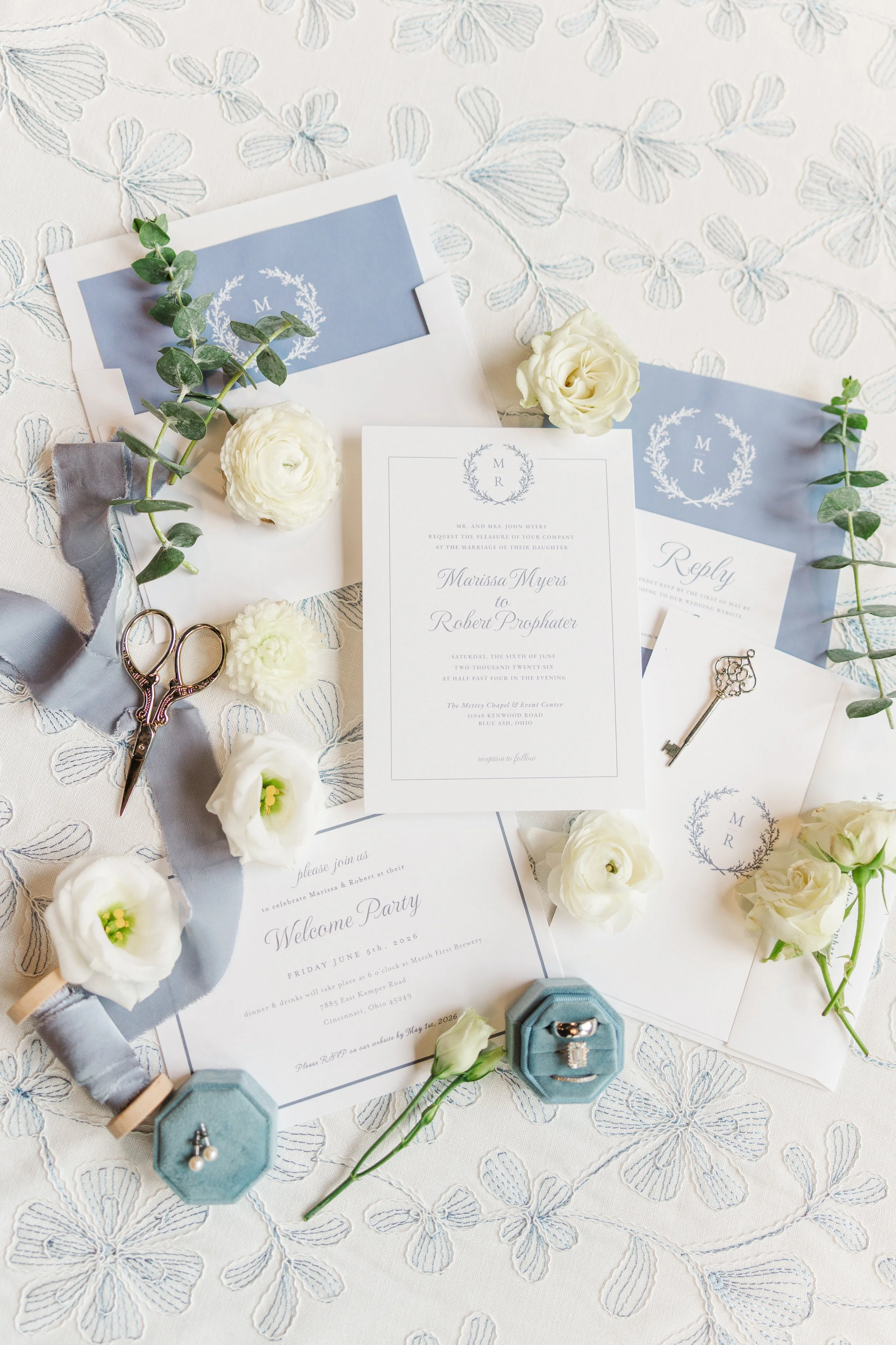 Elegant wedding invitation suite styled with blue stationery, white florals, wax seals, and heirloom details before the wedding day.