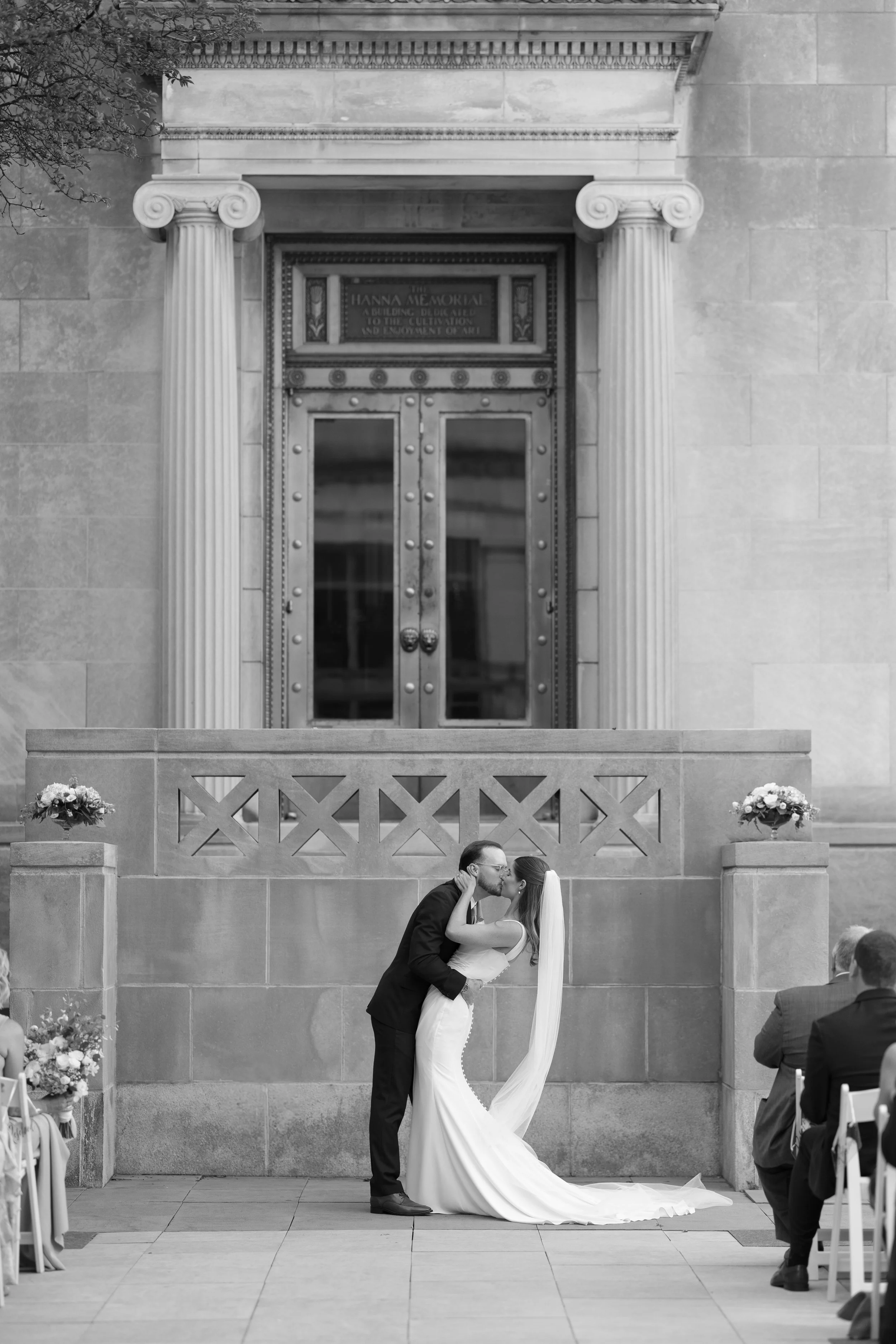 Bride and groom share their first kiss outside the ceremony doors of a historic Cincinnati Art Museum wedding venue.