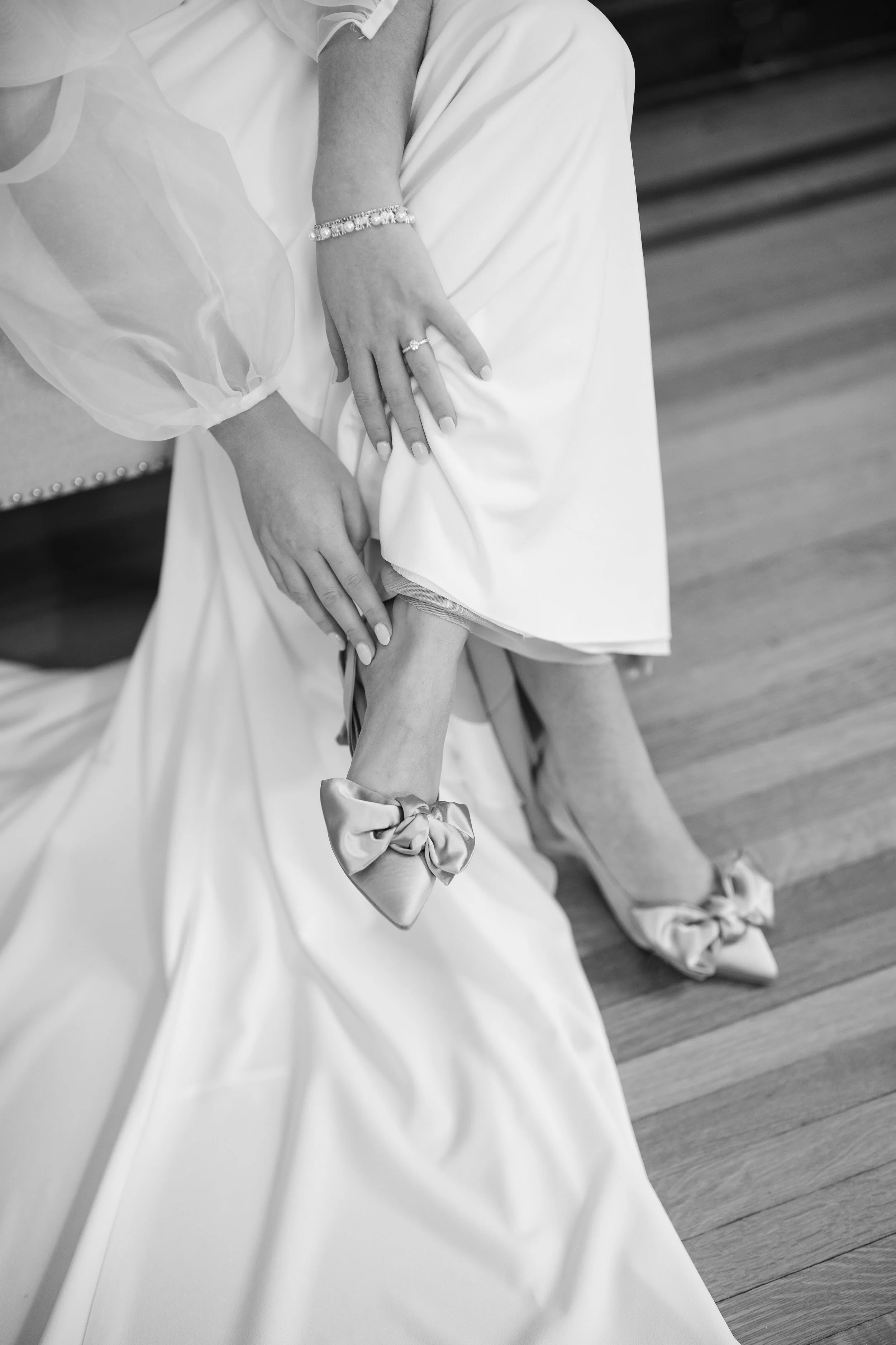Close-up of the bride’s wedding shoes peeking beneath the hem of her gown.