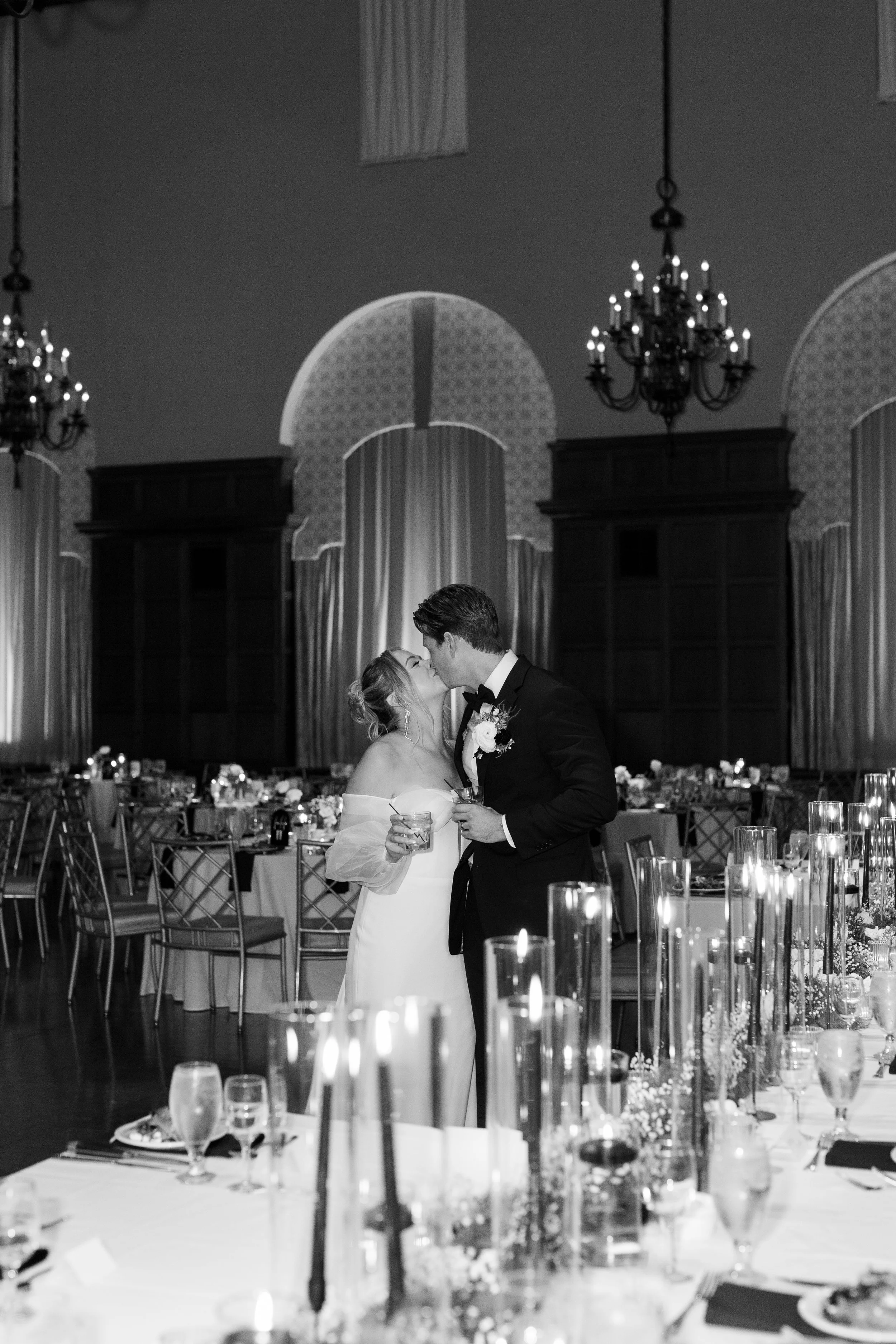 Bride and groom share their first dance surrounded by candlelight during an elegant wedding reception.
