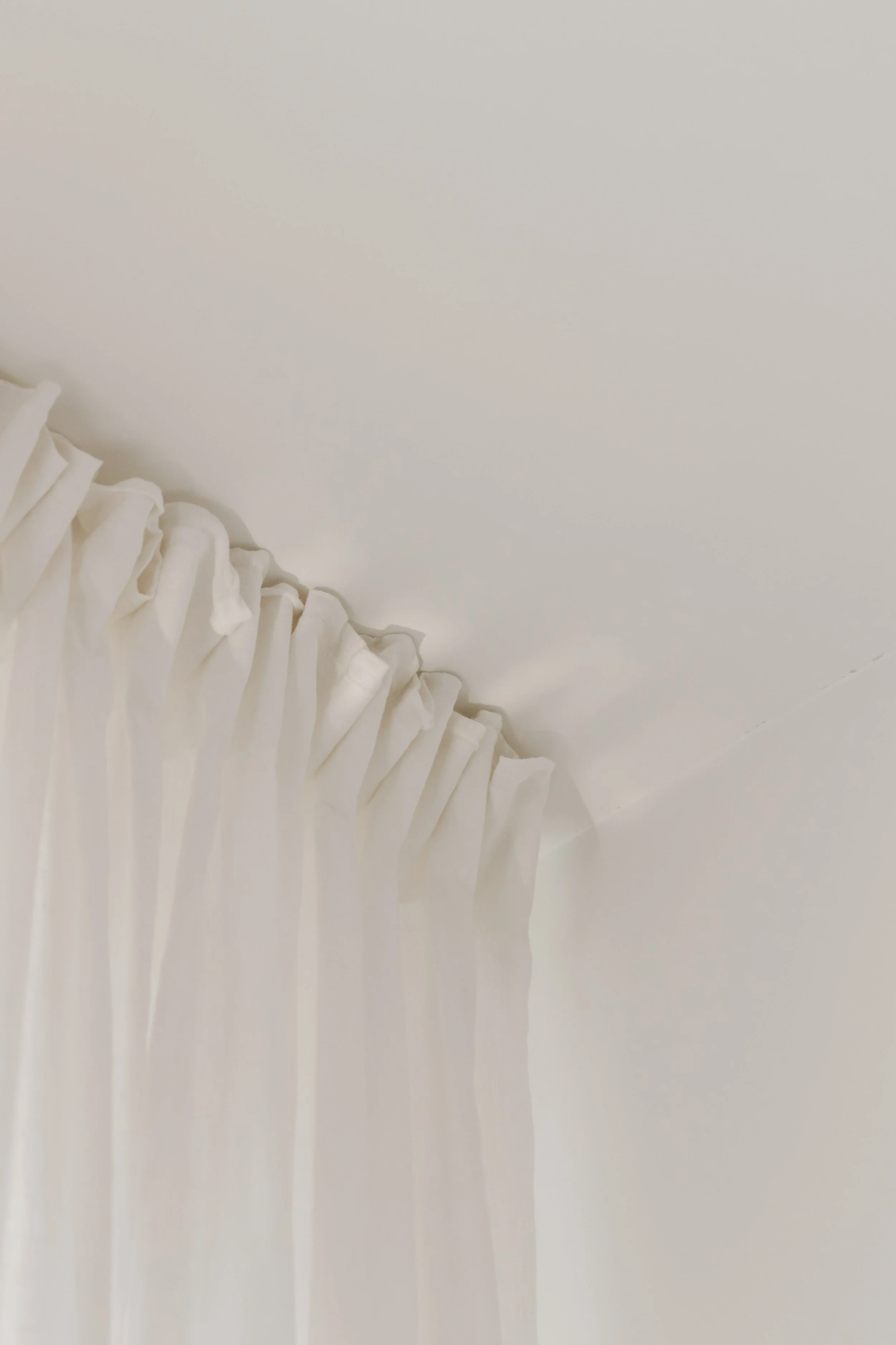 White ceiling with a fabric curtain hanging down on the left side of the image.