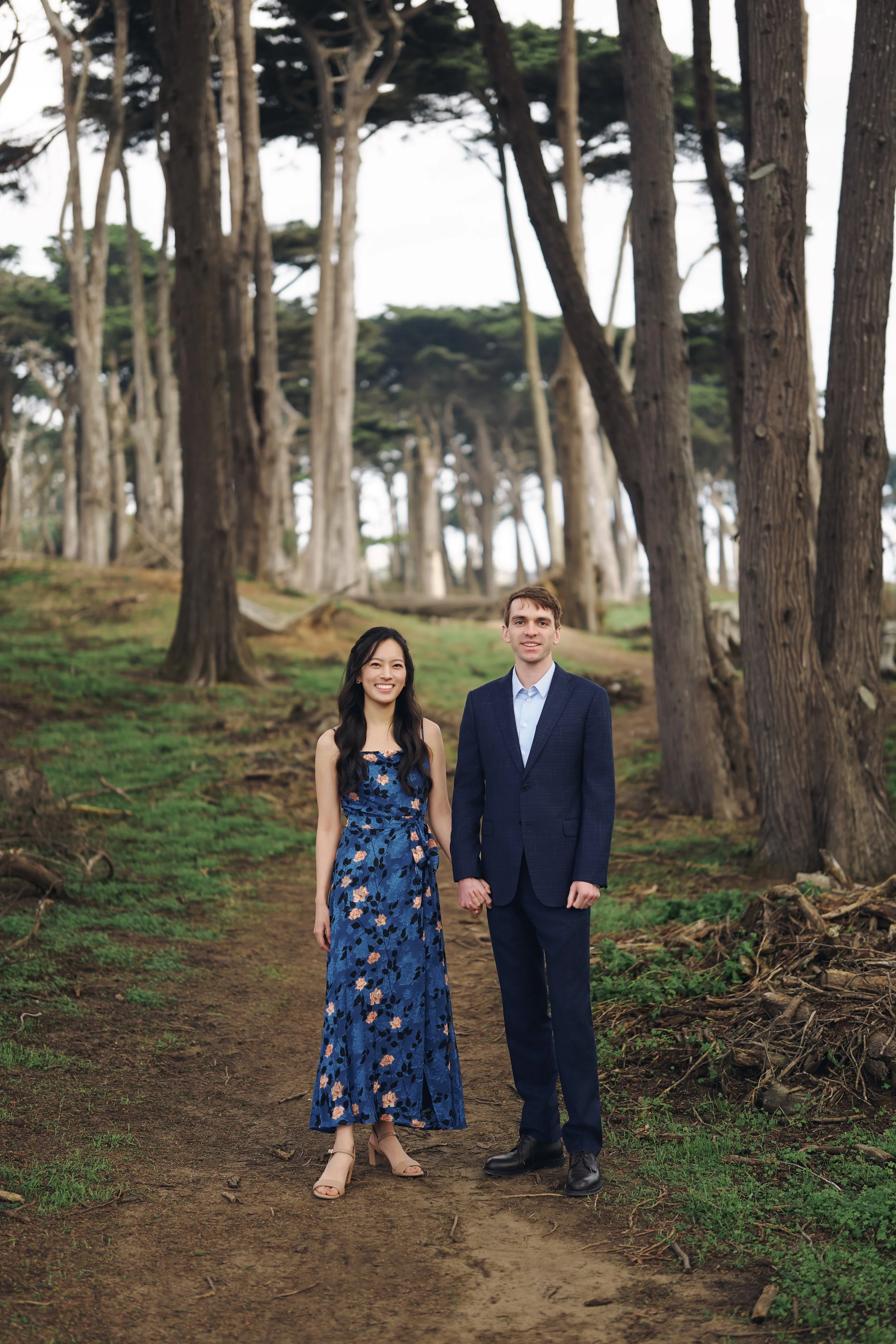Couple holding hands on the Lovers Lane cypress tree path at Lands End, San Francisco engagement session