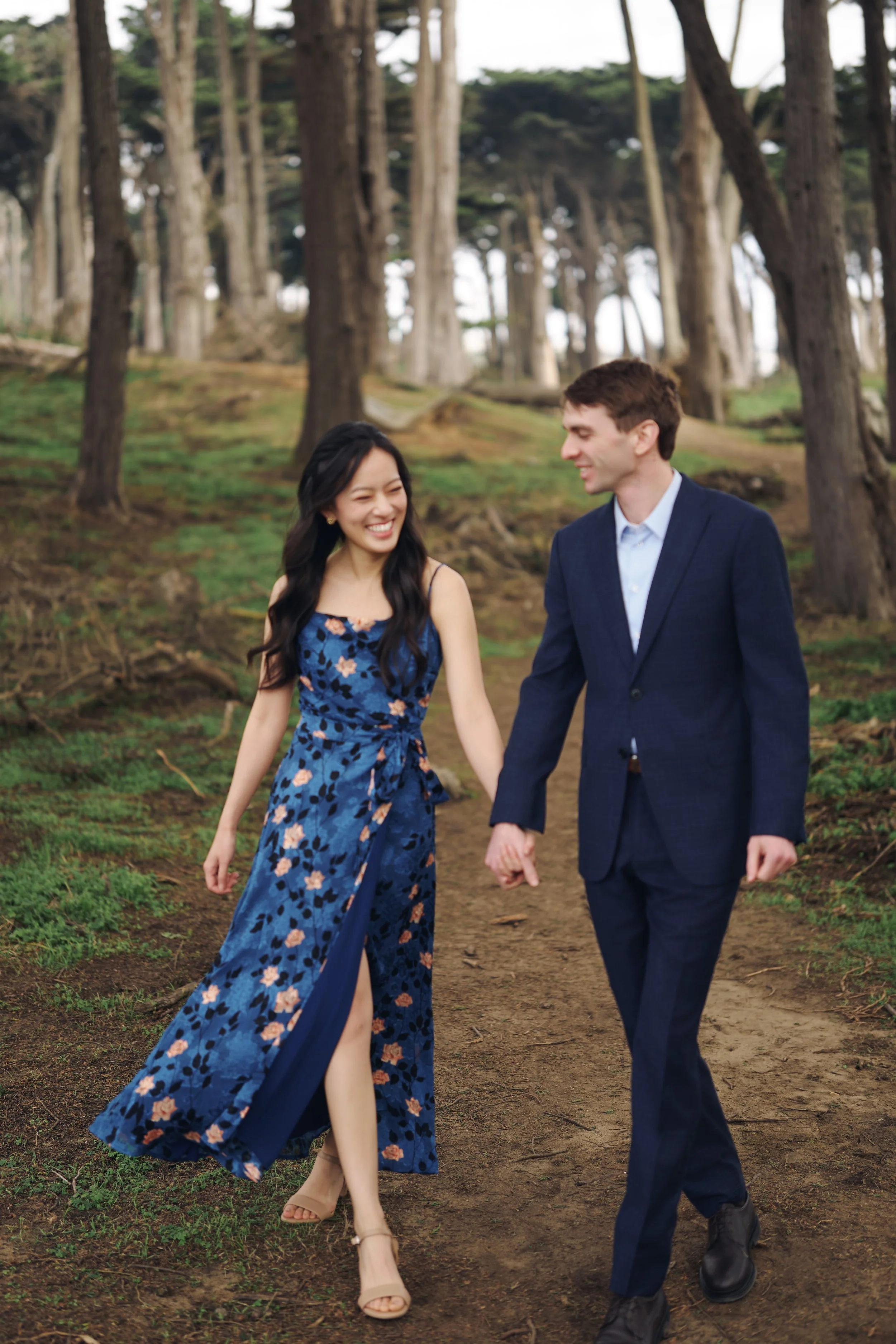 Engagement candid through Lands End cypress trees, San Francisco