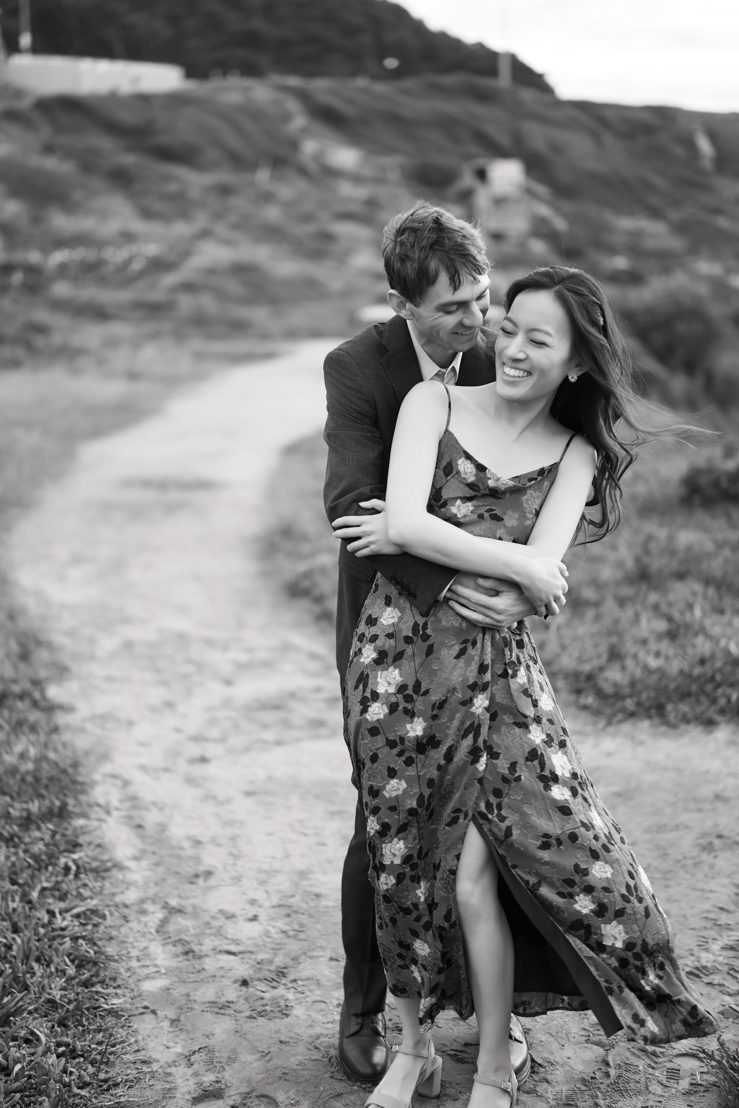 Intimate black and white engagement moment on a Lands End trail
