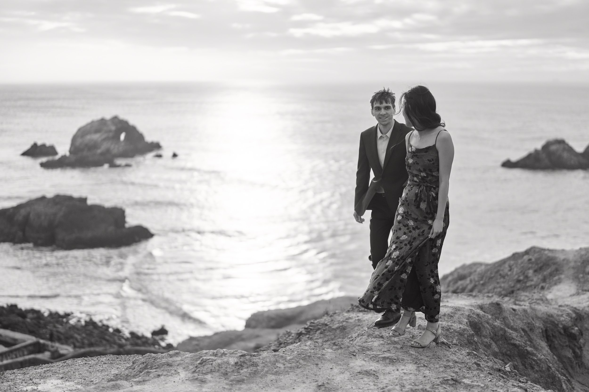 Black and white engagement moment on a Sutro Baths cliff above the Pacific