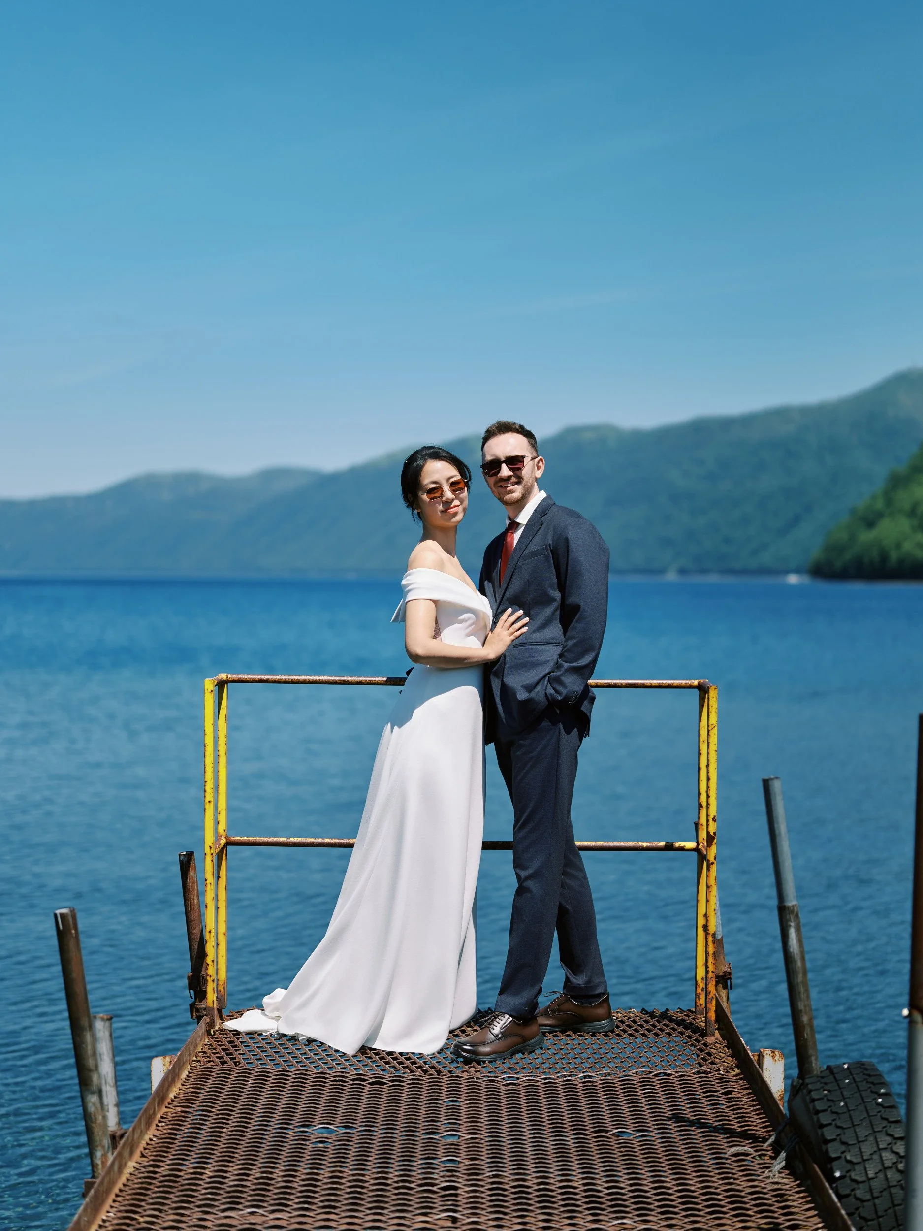 Wide portrait of the bride and groom on the shore of Lake Shikotsu, Hokkaido