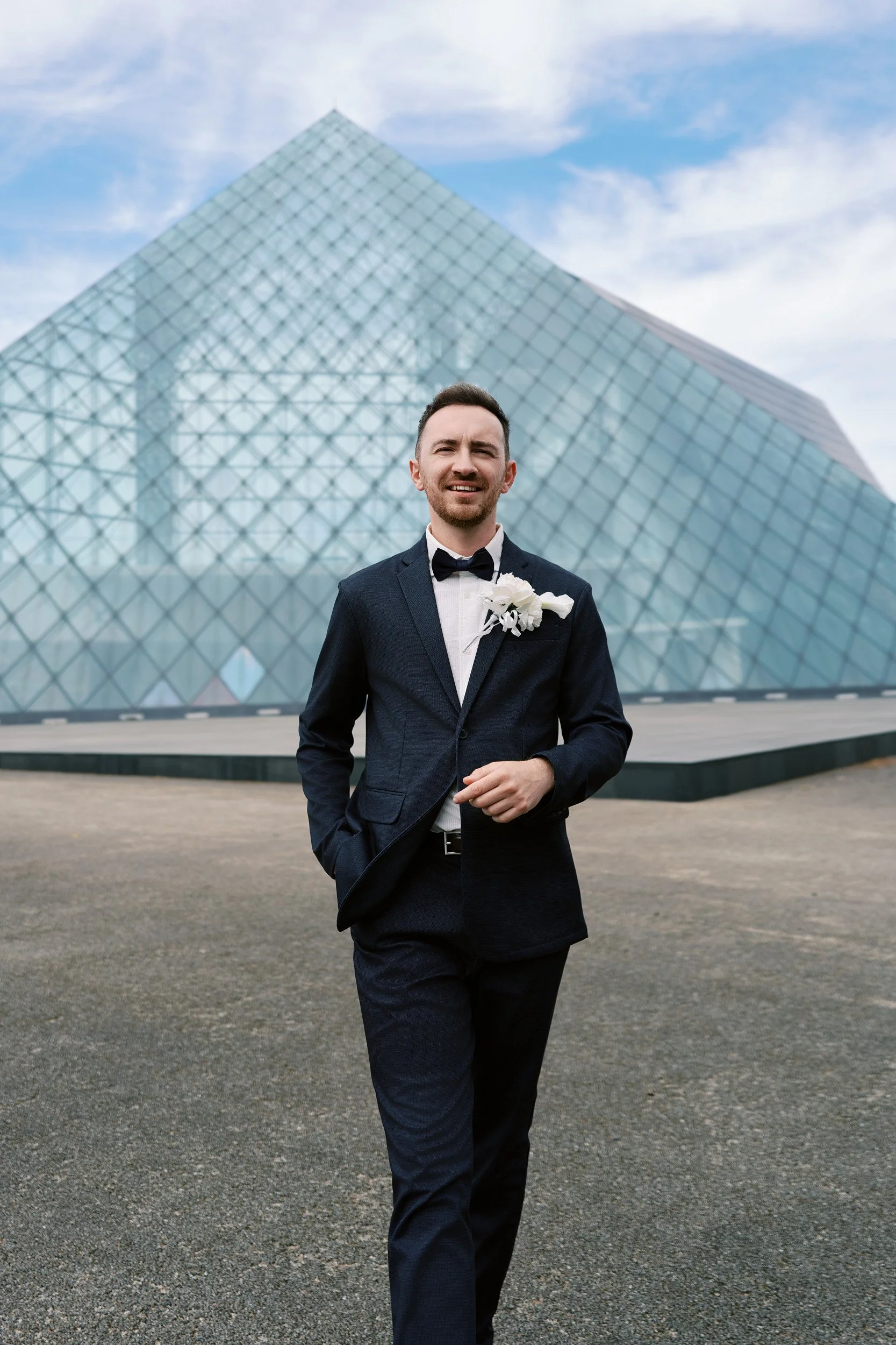 Portrait against the clean lines of the Moerenuma Park glass pyramid