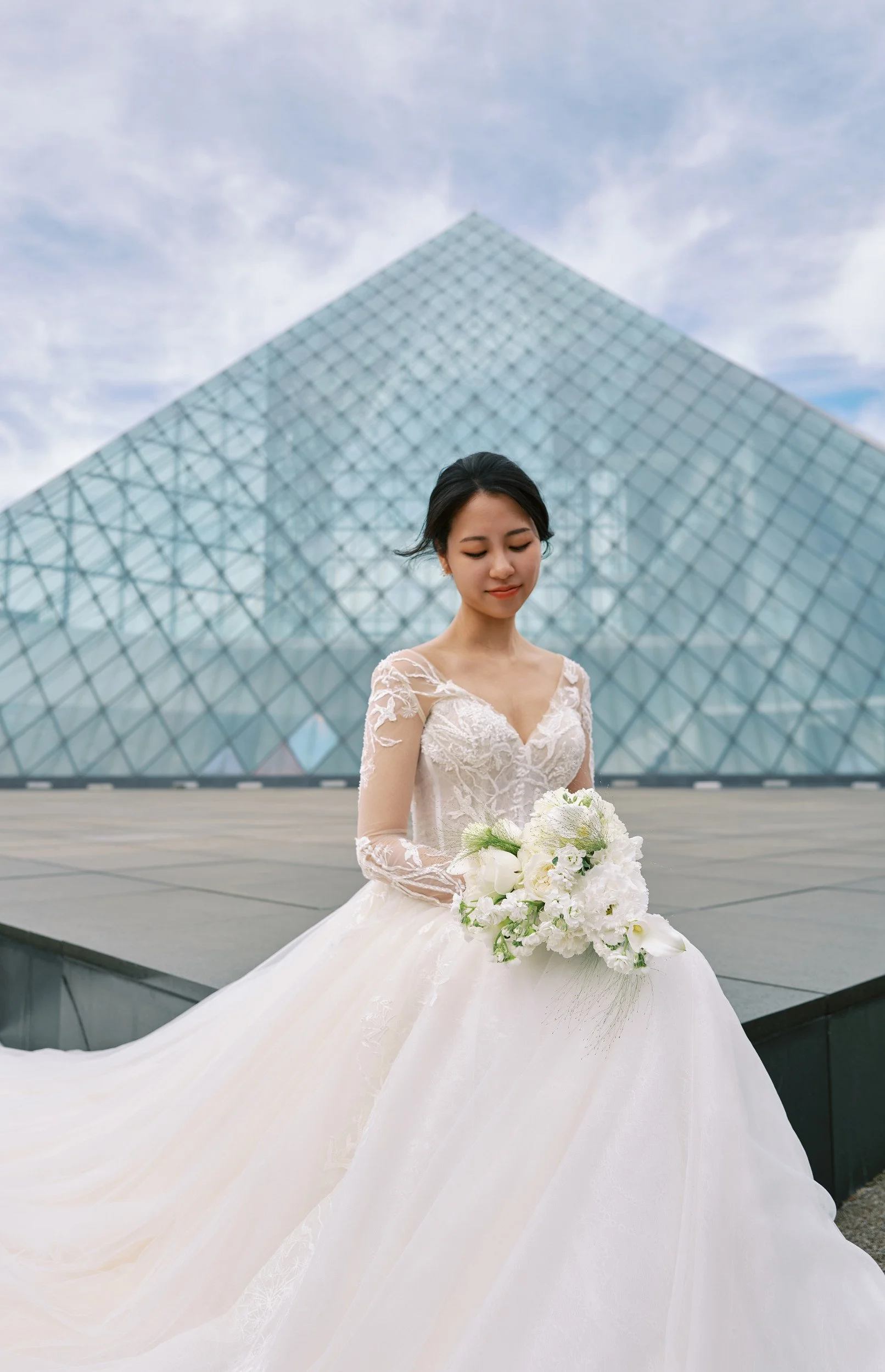 Portrait against the clean lines of the Moerenuma Park glass pyramid