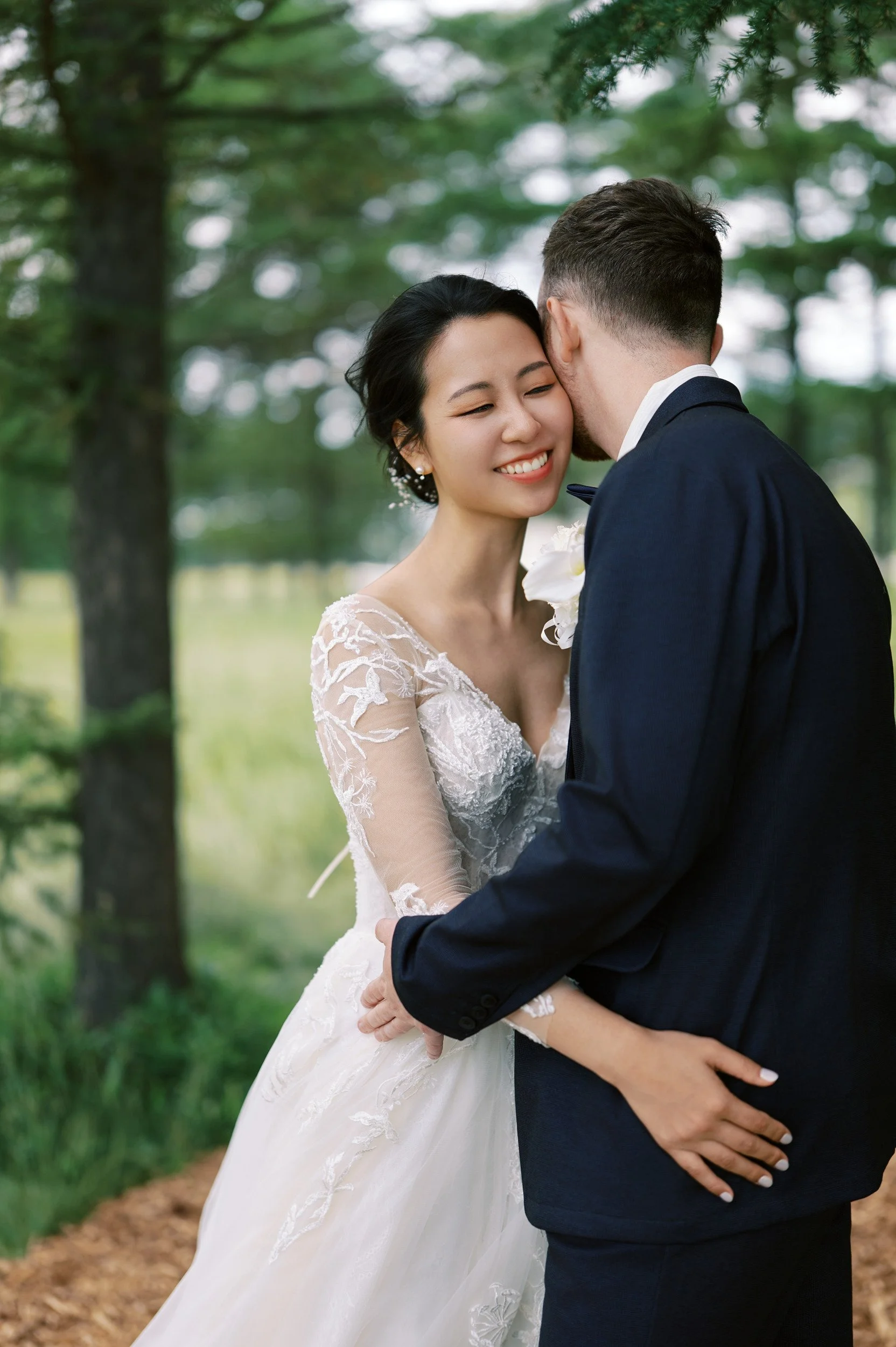 Bride and groom among the trees at Moerenuma Park in soft filtered light