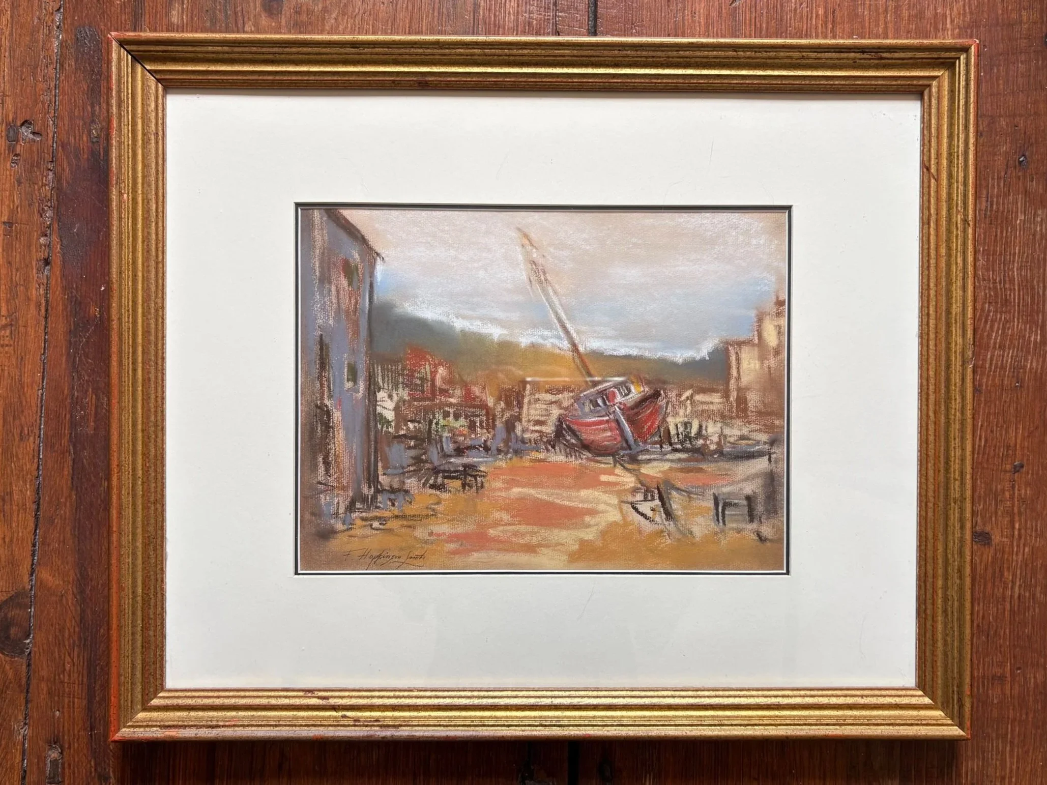 A framed watercolor painting of boats on water, with a cloudy sky and shoreline in the background, signed at the bottom.