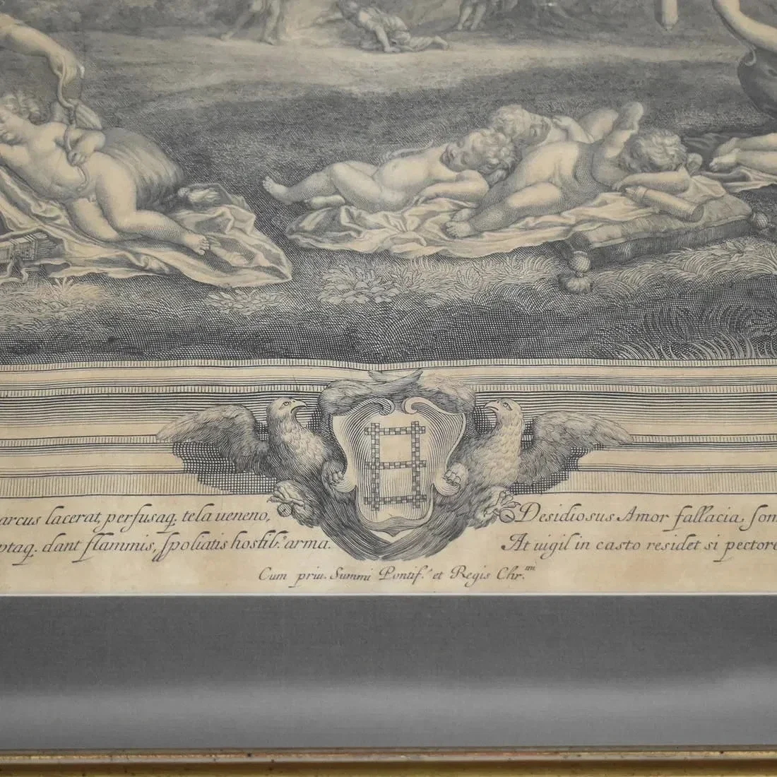 A detailed black-and-white illustration featuring cherubs and a decorative crest with two eagles, accompanied by Latin script at the bottom.