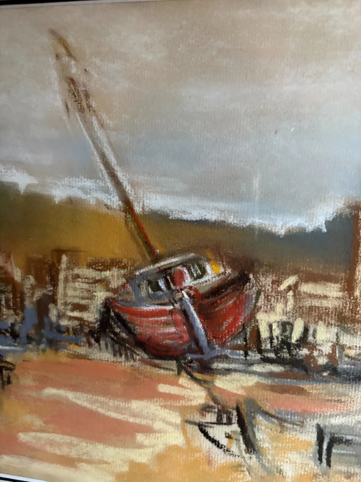 A small red and black boat with an outboard motor is placed indoors on a wooden surface, with a painting-style background.