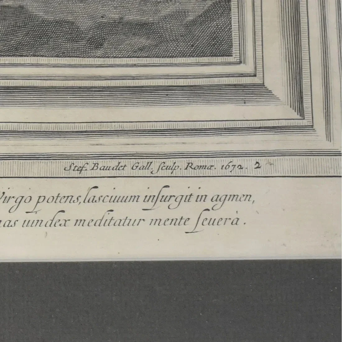 Close-up of an old engraved print with Latin text and decorative border, referencing artist Steg Baudot Gall, 1677.