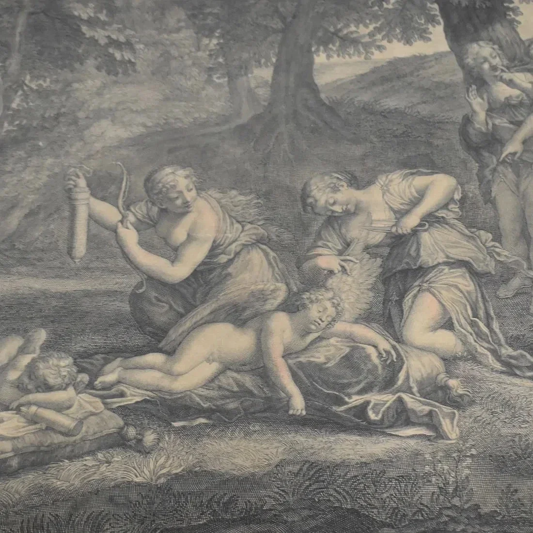A classical black and white engraving depicting a mythological scene with three women, one holding a snake, another with a sword, and a child lying on the ground, set outdoors with trees in the background.