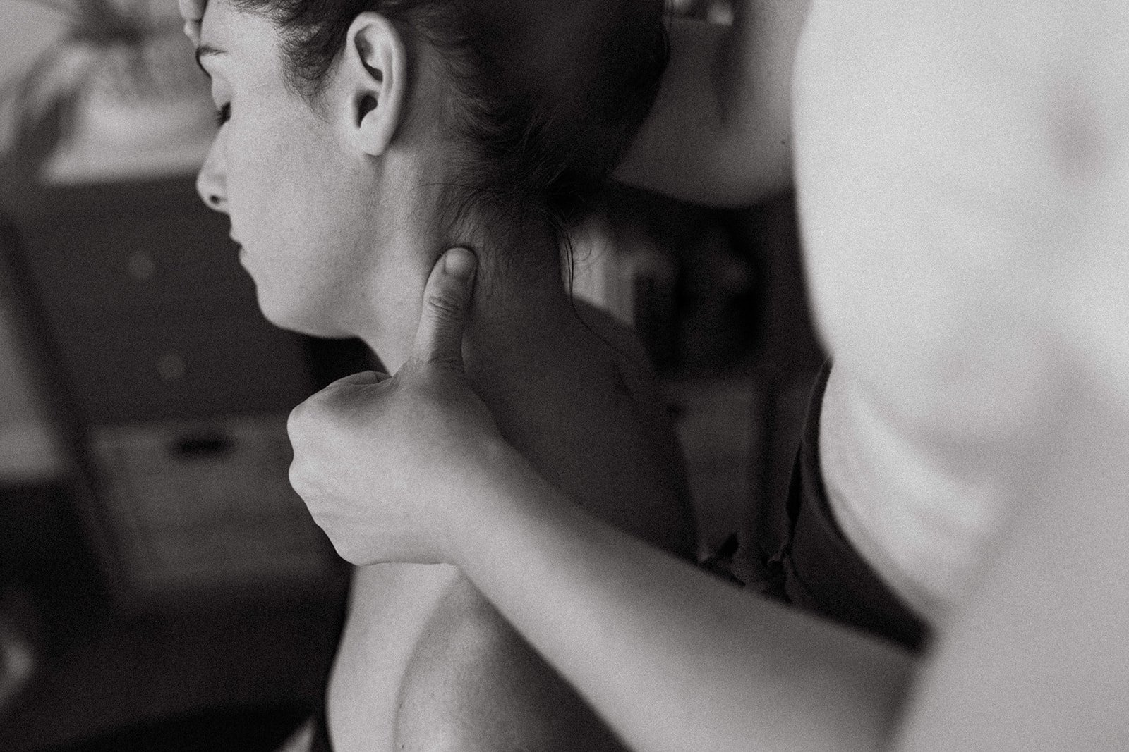 A stressed woman receiving a massage or therapy or bodywork or energy medicine modalities from Tania Marie, Tania Edwards, applying pressure to her neck and shoulder area.