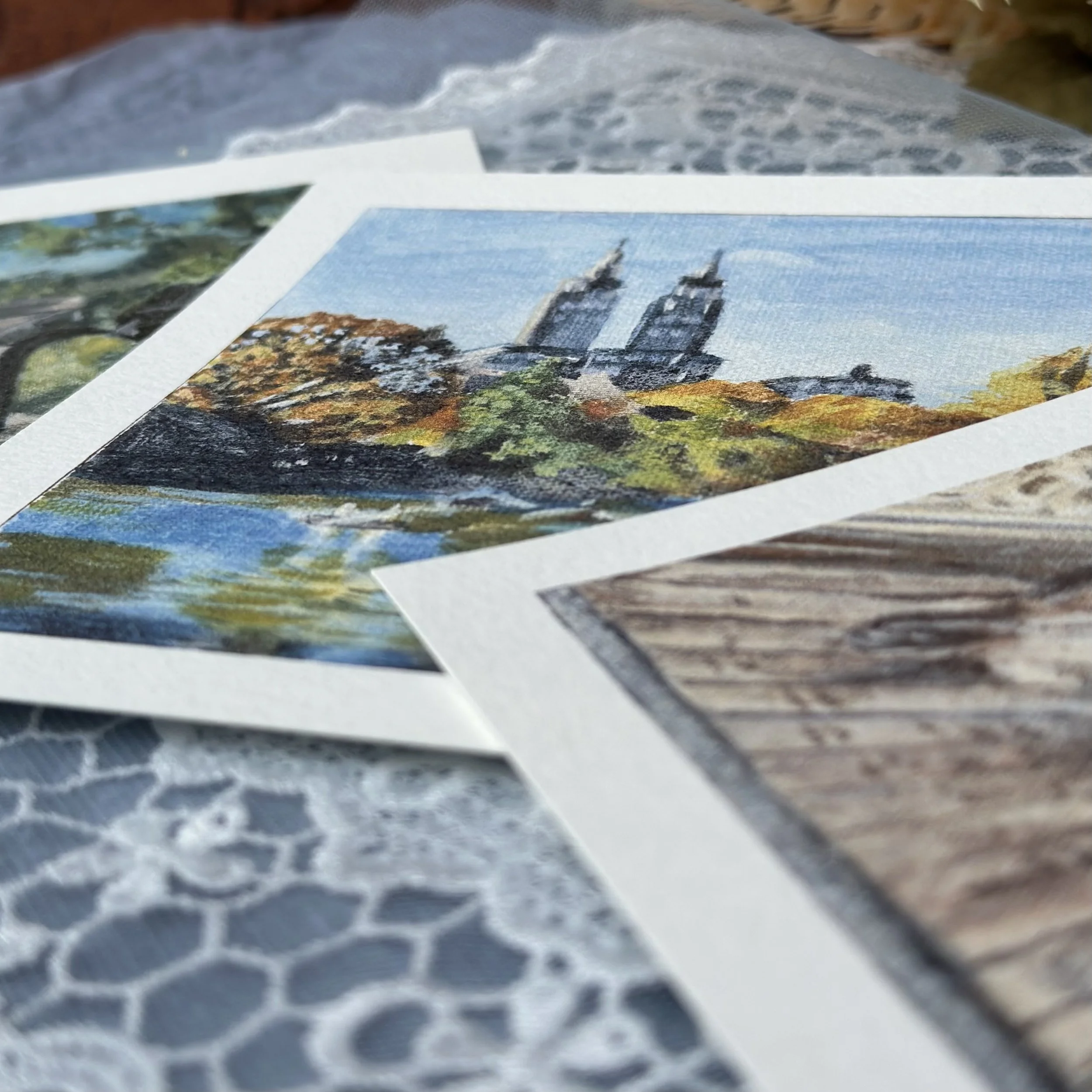 Close-up of a pile of photographs with an image of a historic church or cathedral in the center.