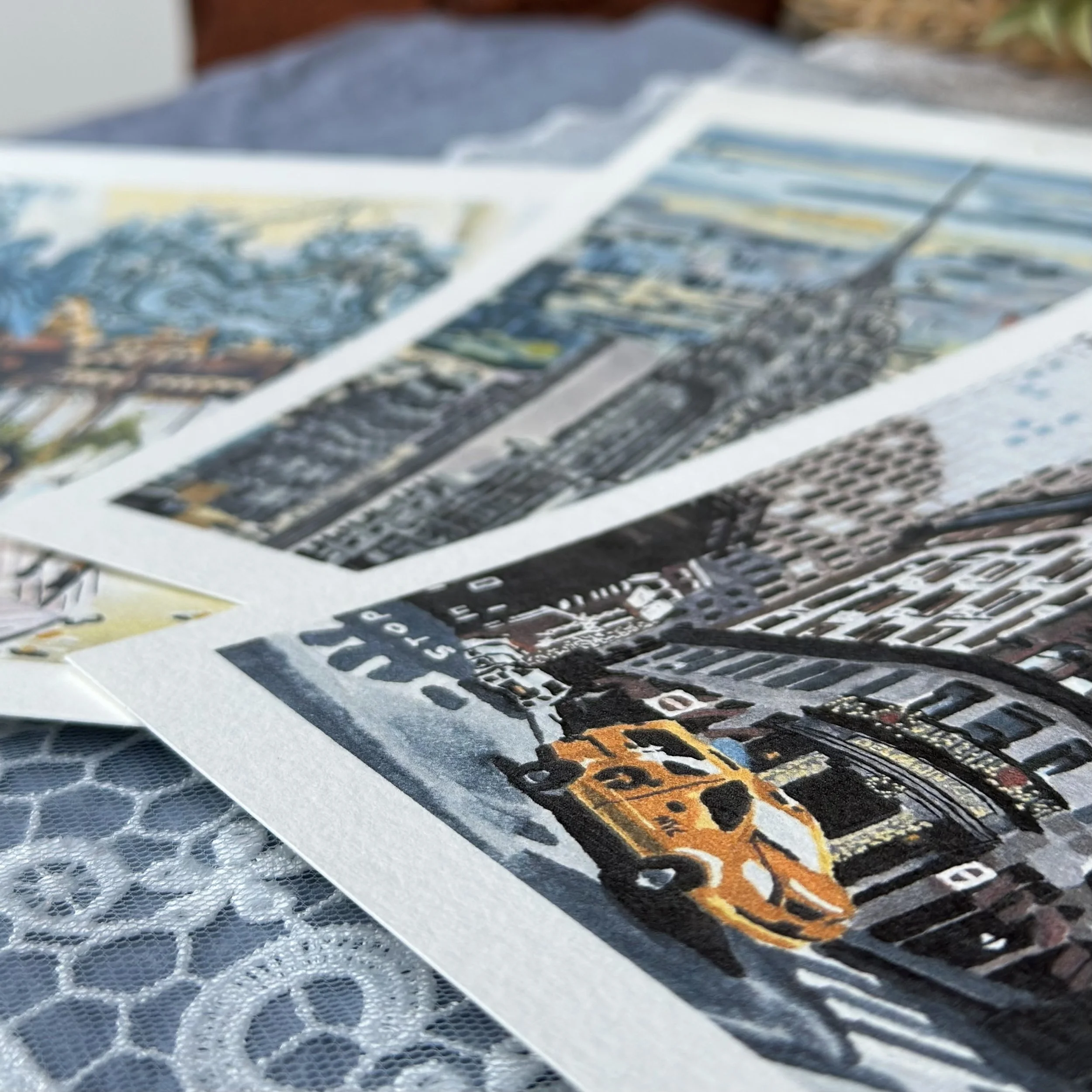 Close-up of printed photographs or posters with vibrant colors, arranged on a table or surface.