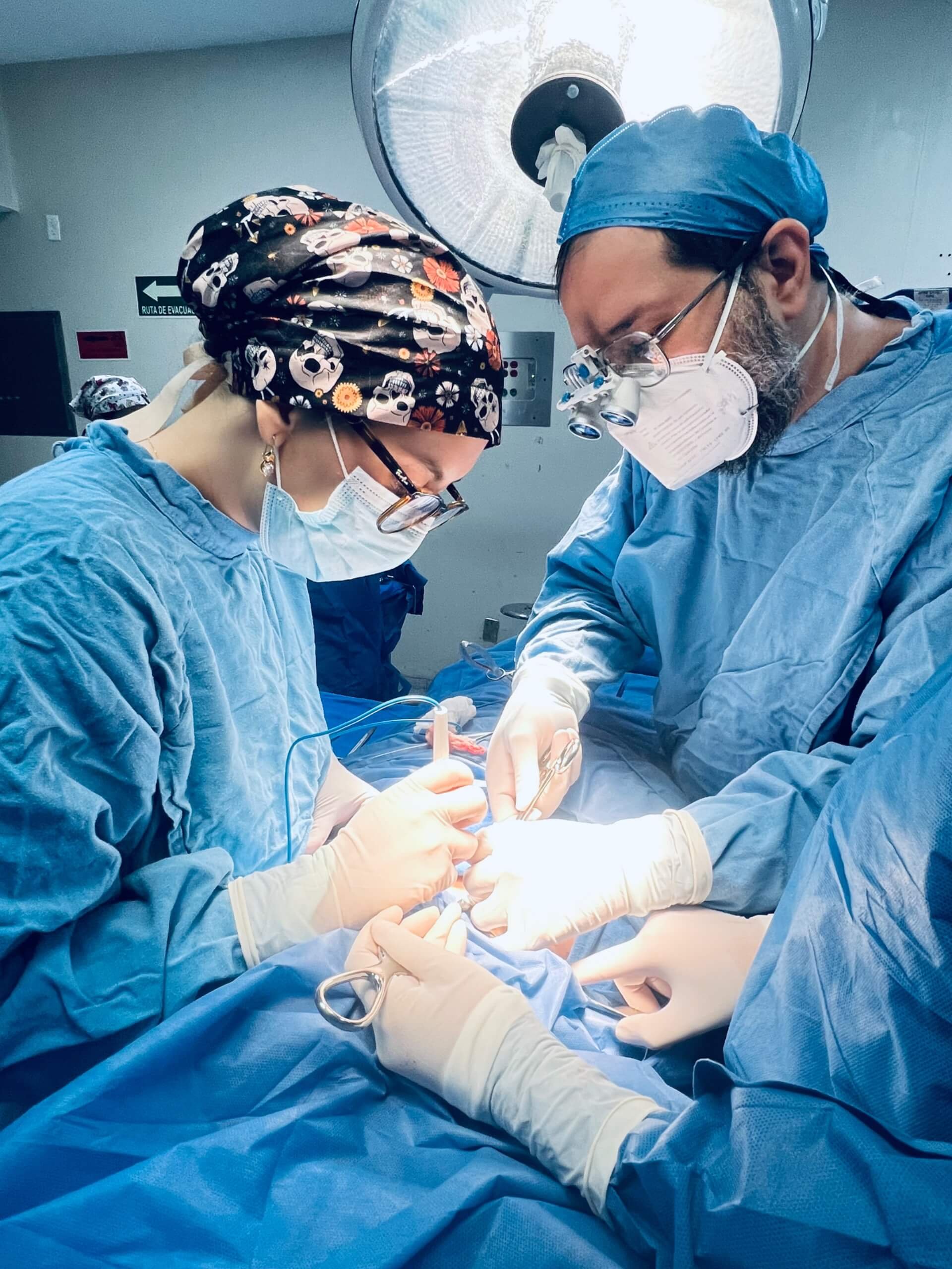 El Dr. Carlos Gustavo Rivera y compañera cirujana realizando una operación de paratiroides
