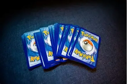 Multiple Pokémon trading cards spread out on a dark surface.