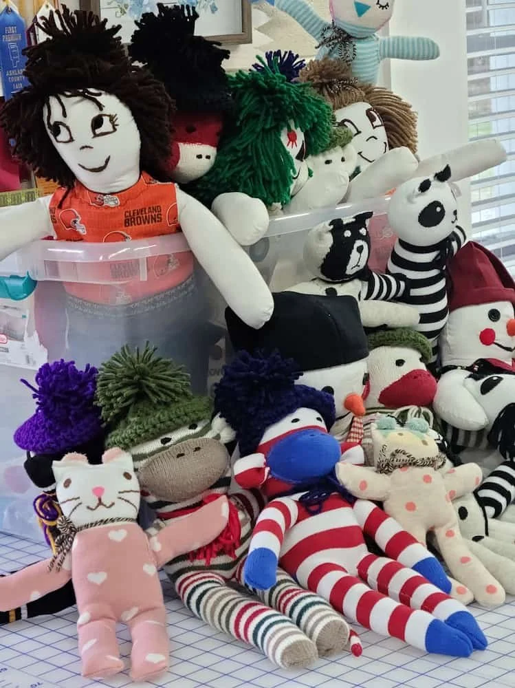 A box of handmade dolls and stuffed animals sewn by a volunteer to give to children