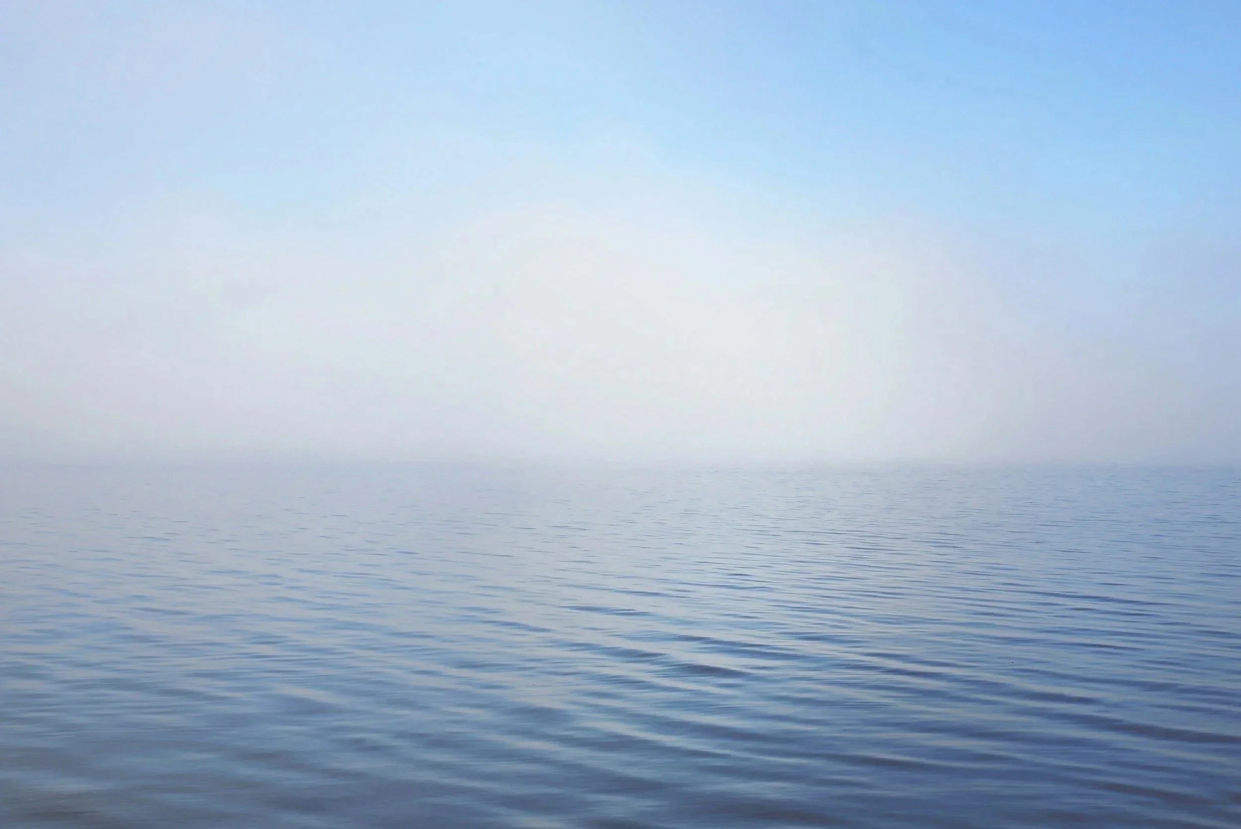 Calm ocean with gentle waves under a clear blue sky.