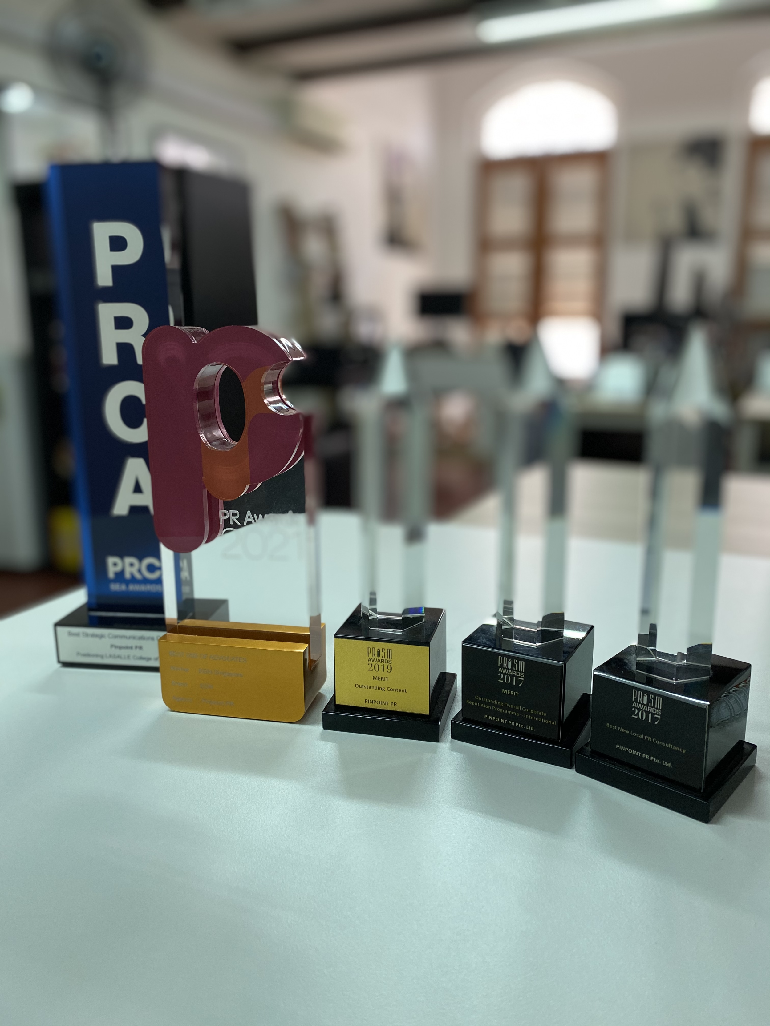 Several award trophies and plaques won by, or awarded to, Pinpoint PR Pte. Ltd.