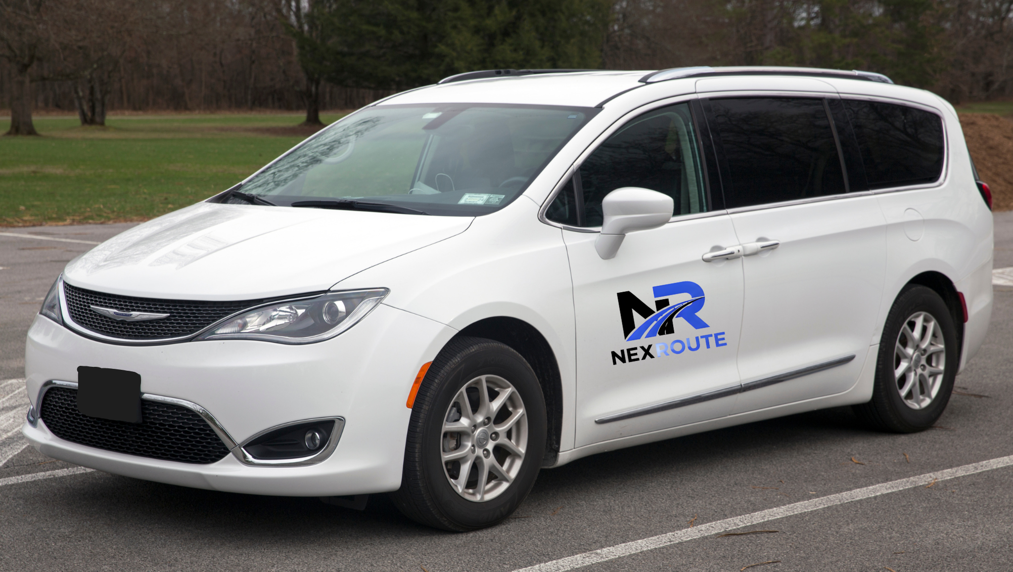 White minivan parked in a lot with a NexRoute logo on the side.