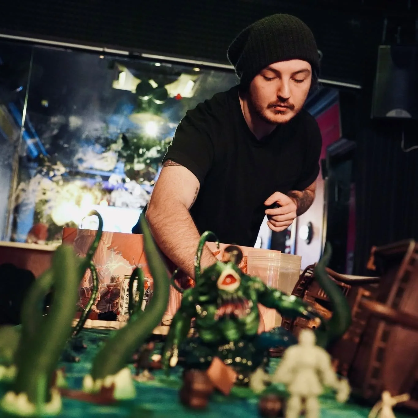 Game master Patrick reaches over the D&D game board.