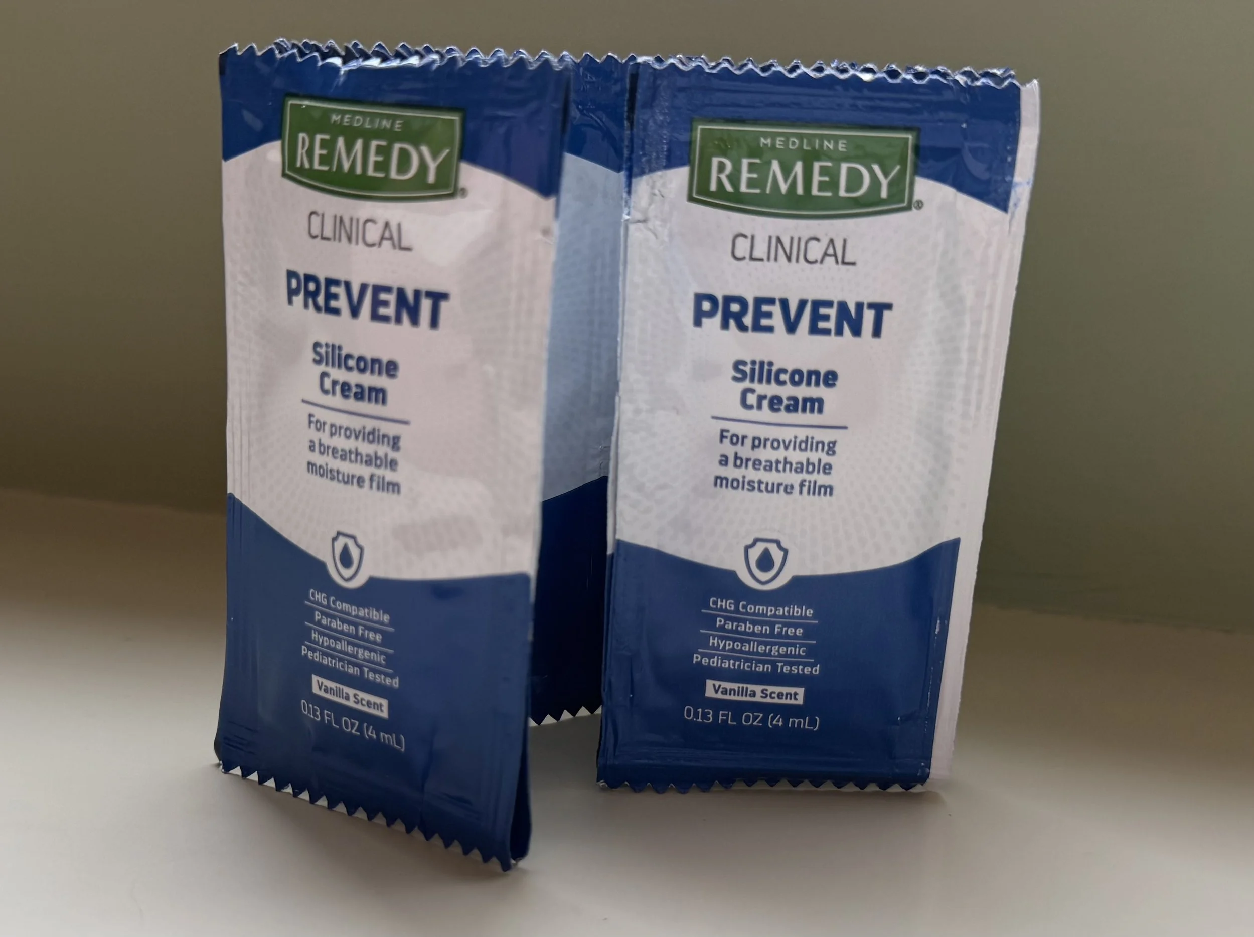 Two small blue and white boxes of Medline Remedy clinical prevent silicone cream placed side by side on a white surface against a light-colored background.