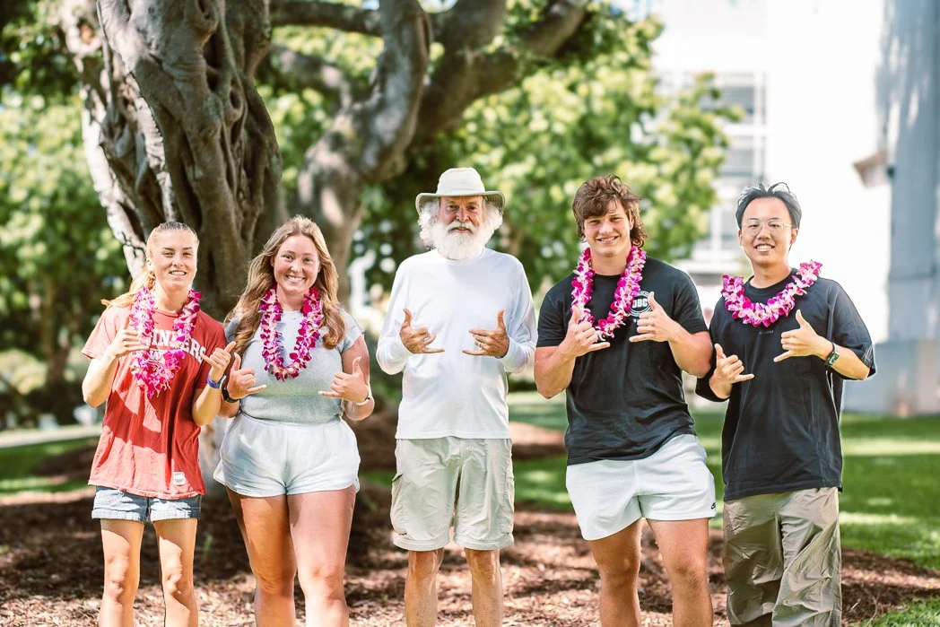 WPI students Caitlin Murphy, Riann Divine, Dylan Wagner, and Zihan Li pose with project mentor Rich Downs in Honolulu following their project interview, wearing lei after completing their ArcGIS StoryMaps conservation project.