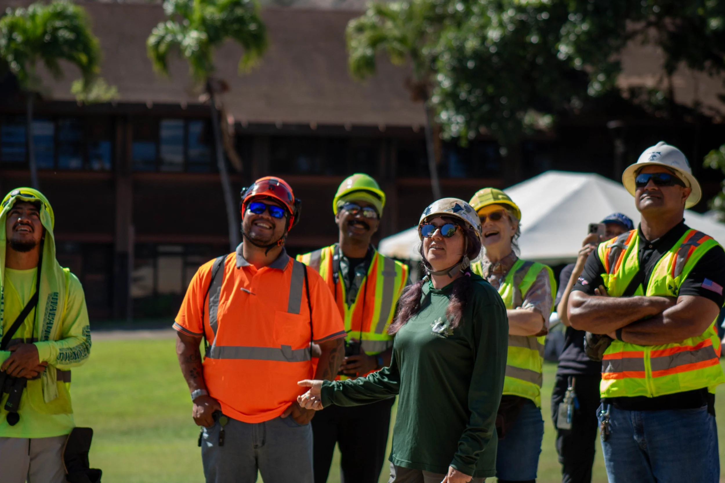 Wildlife biologist and certified arborist Ilana Nimz explains wildlife-aware tree care practices to a group of professional arborists in high-visibility gear during the outdoor demonstration session at Kapiʻolani Community College.