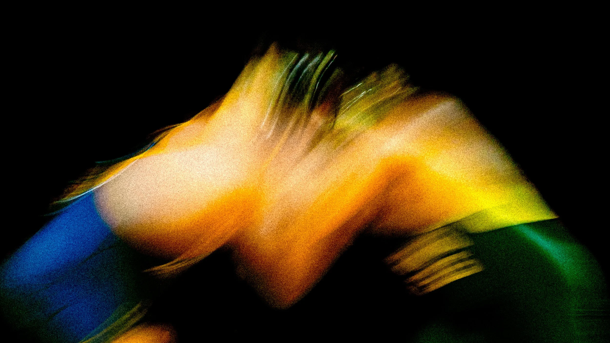 Abstract colorful blurred image with streaks of yellow, green, and blue on a black background.