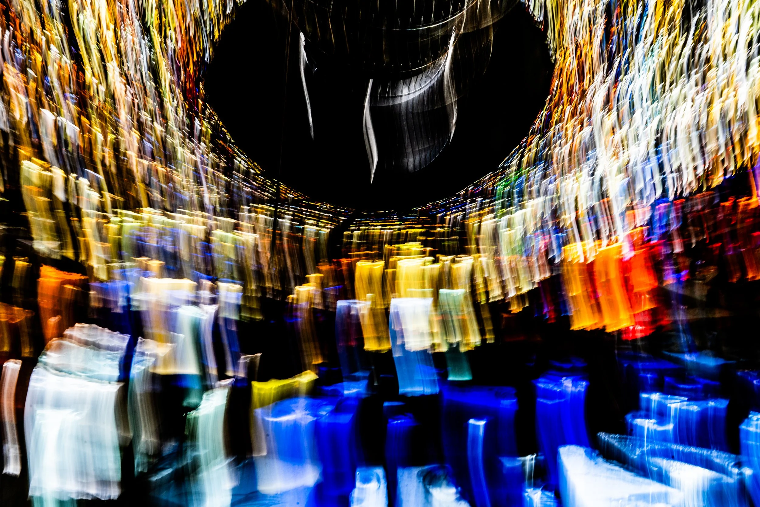 Abstract blurred colorful lights streaking in motion with a dark background.