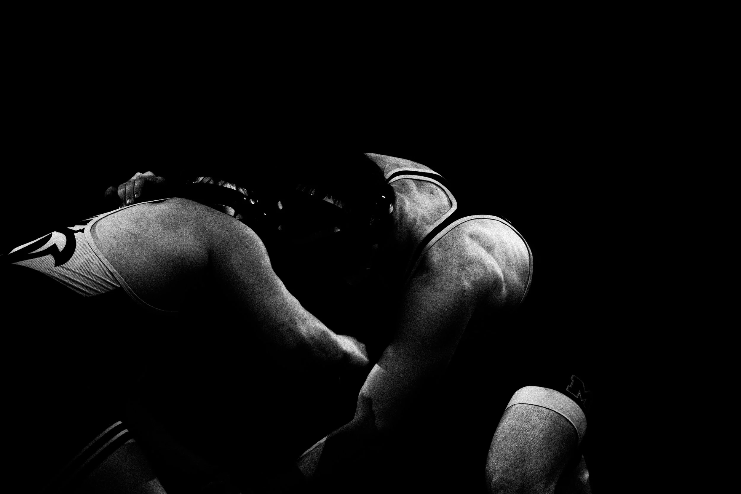 Black and white photo of two wrestlers engaged in a match, with one wrestler pinning the other.