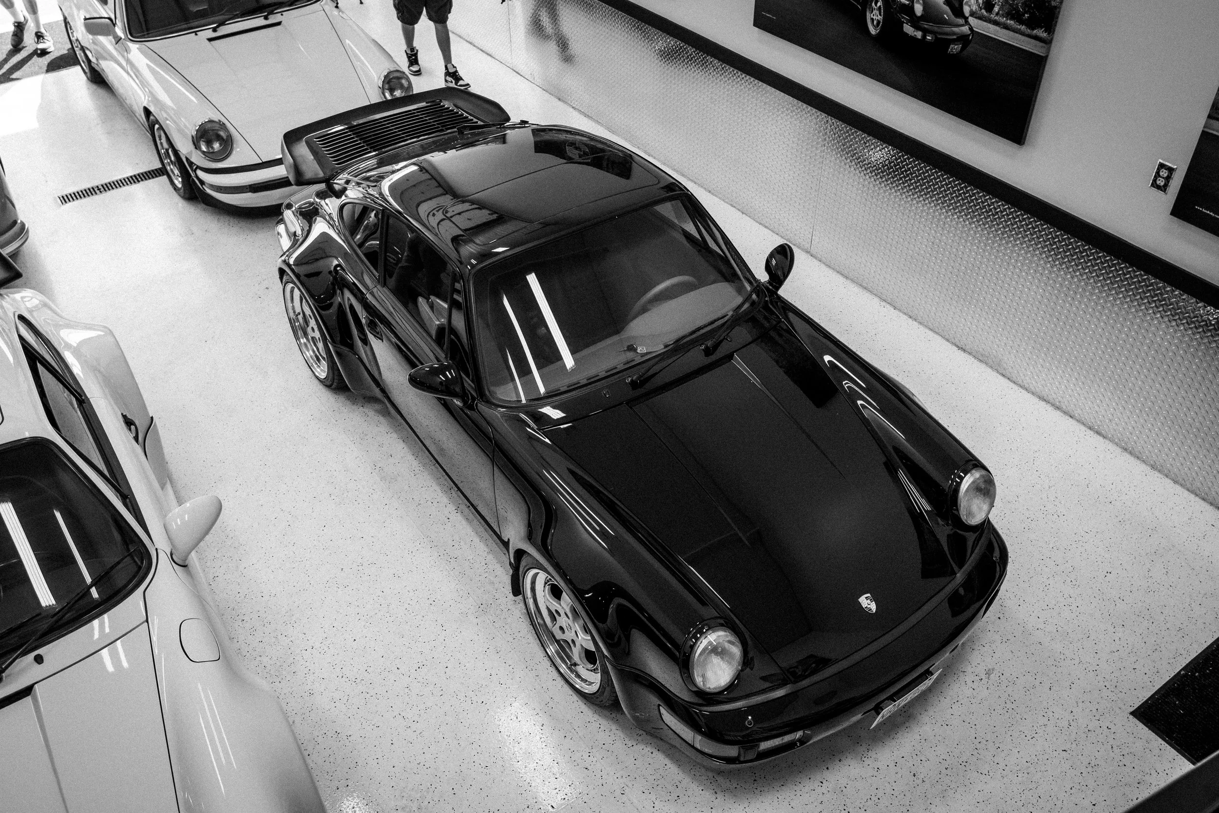 Black sports car with a sunroof parked inside a car showroom.