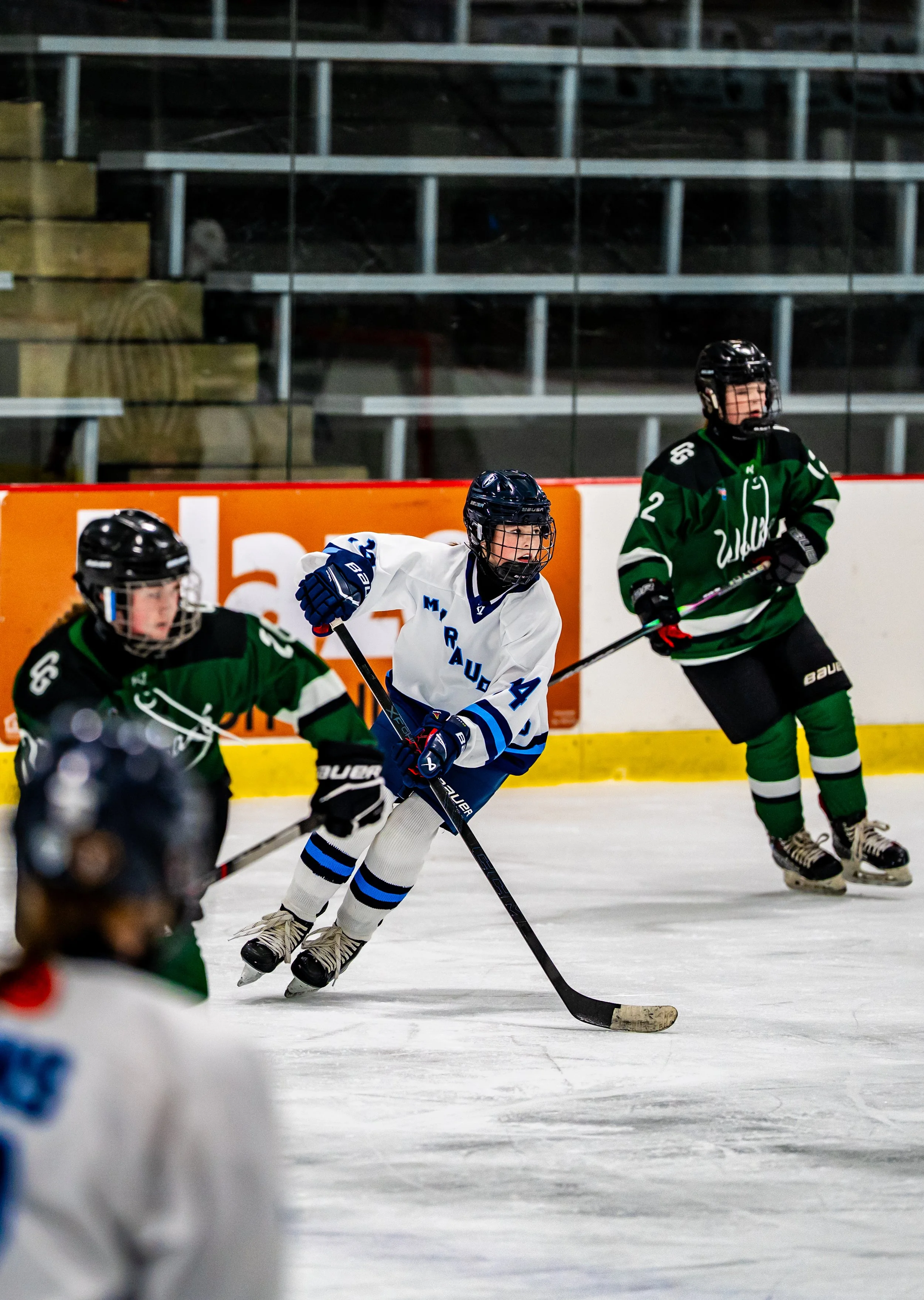 Hockey players in action during a game on an ice rink.