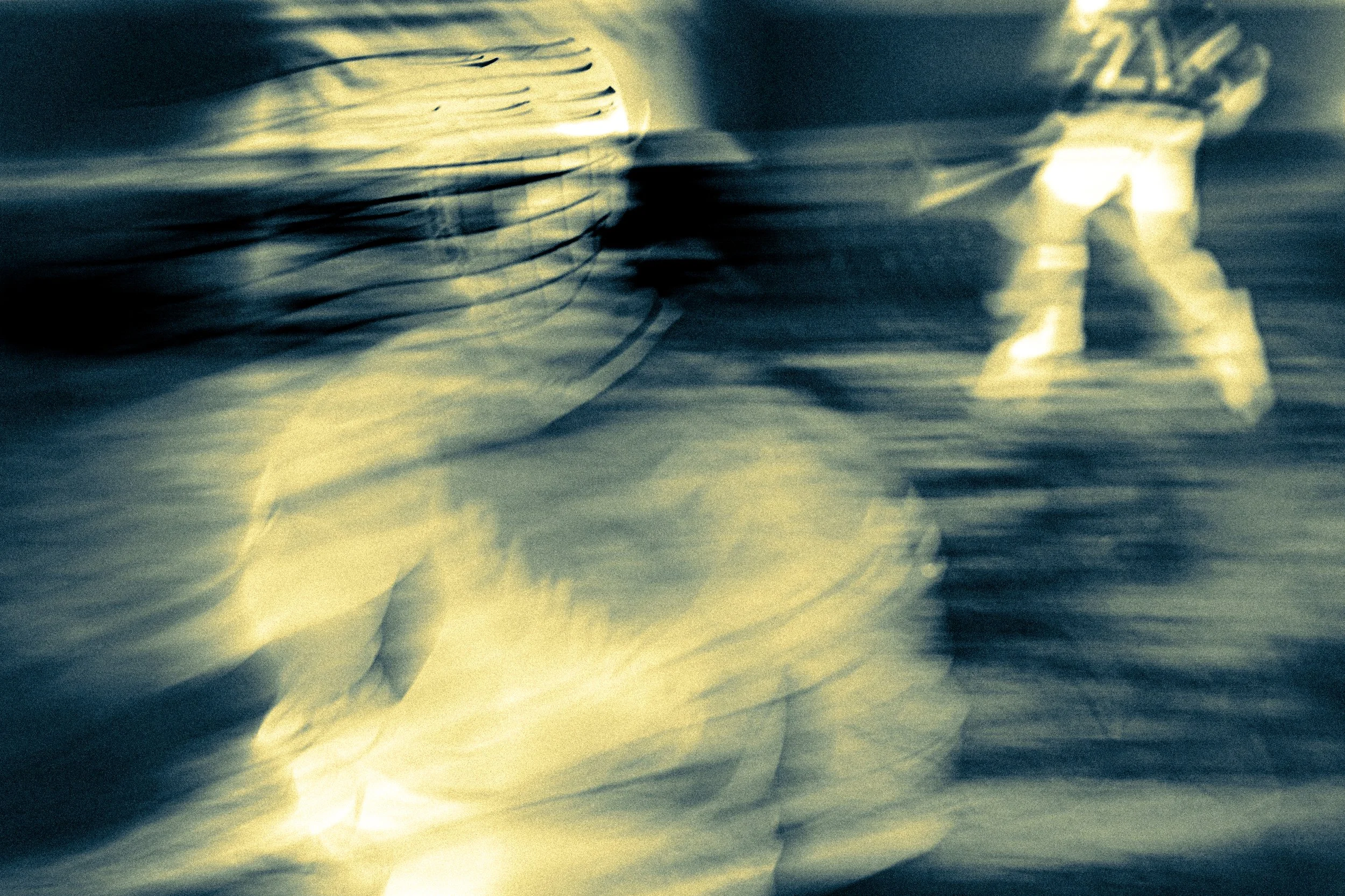 A blurry, close-up image of crumpled paper with a dark and yellowish color tone.